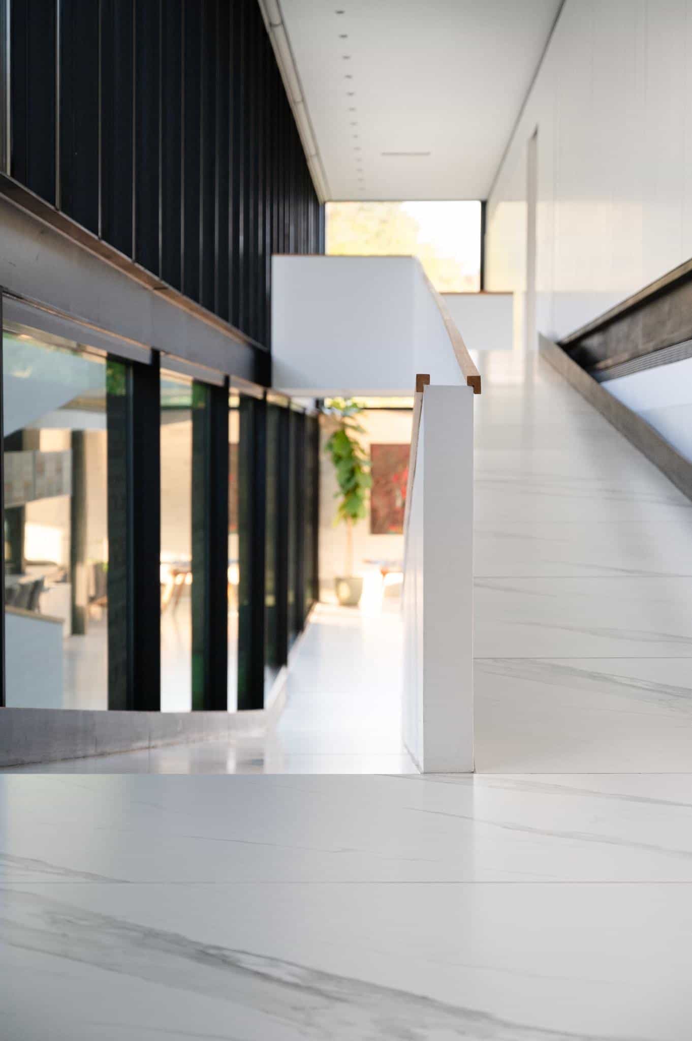 Pacheco House Access Ramp Detail Interior ramp at Pacheco House leading to common areas, aligned with vertical glass window mullions.
