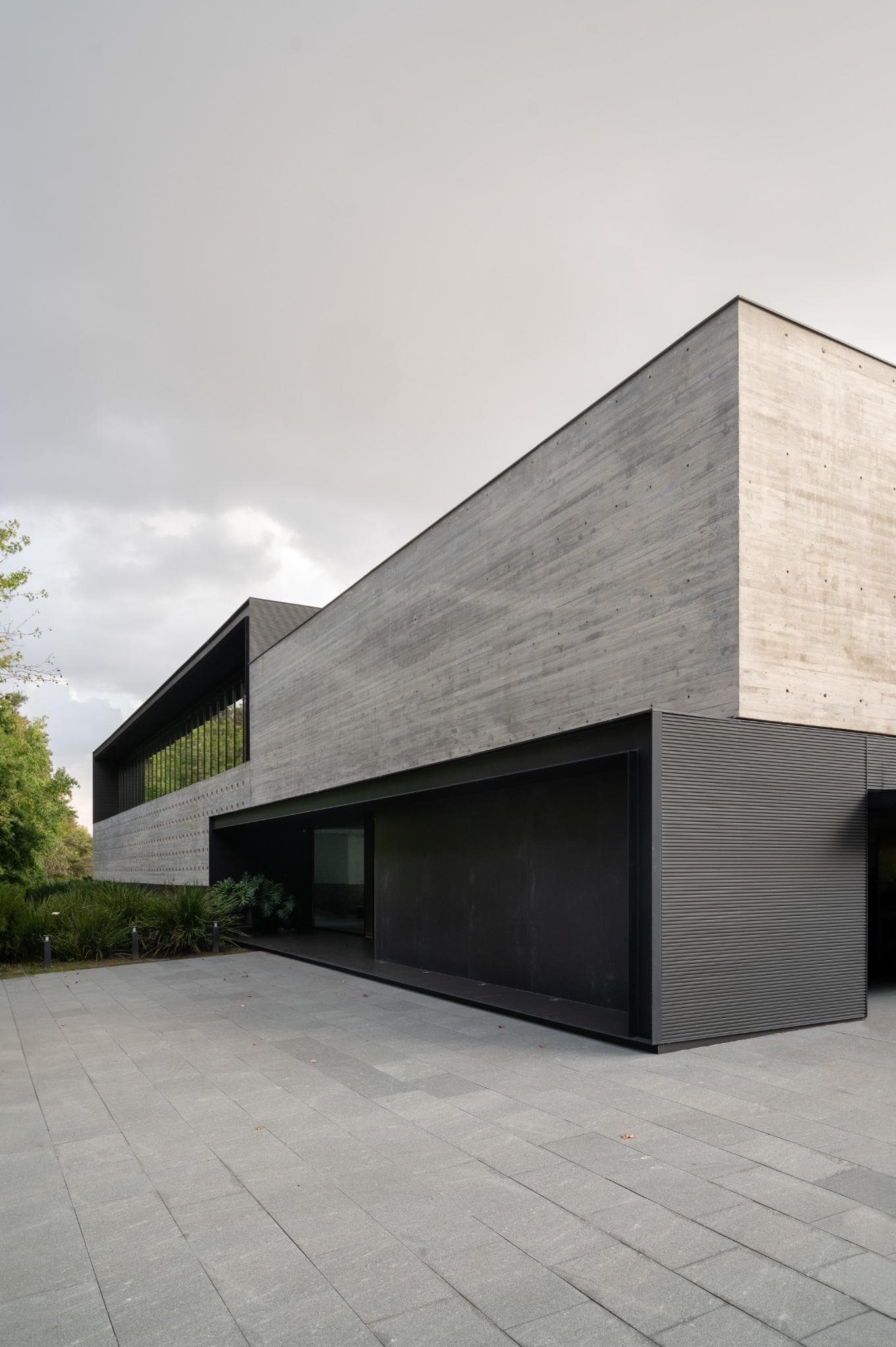 Pacheco House Exterior Front Corner View Modern concrete exterior of Pacheco House by A4estudio, showcasing angular geometry and minimalist landscaping.