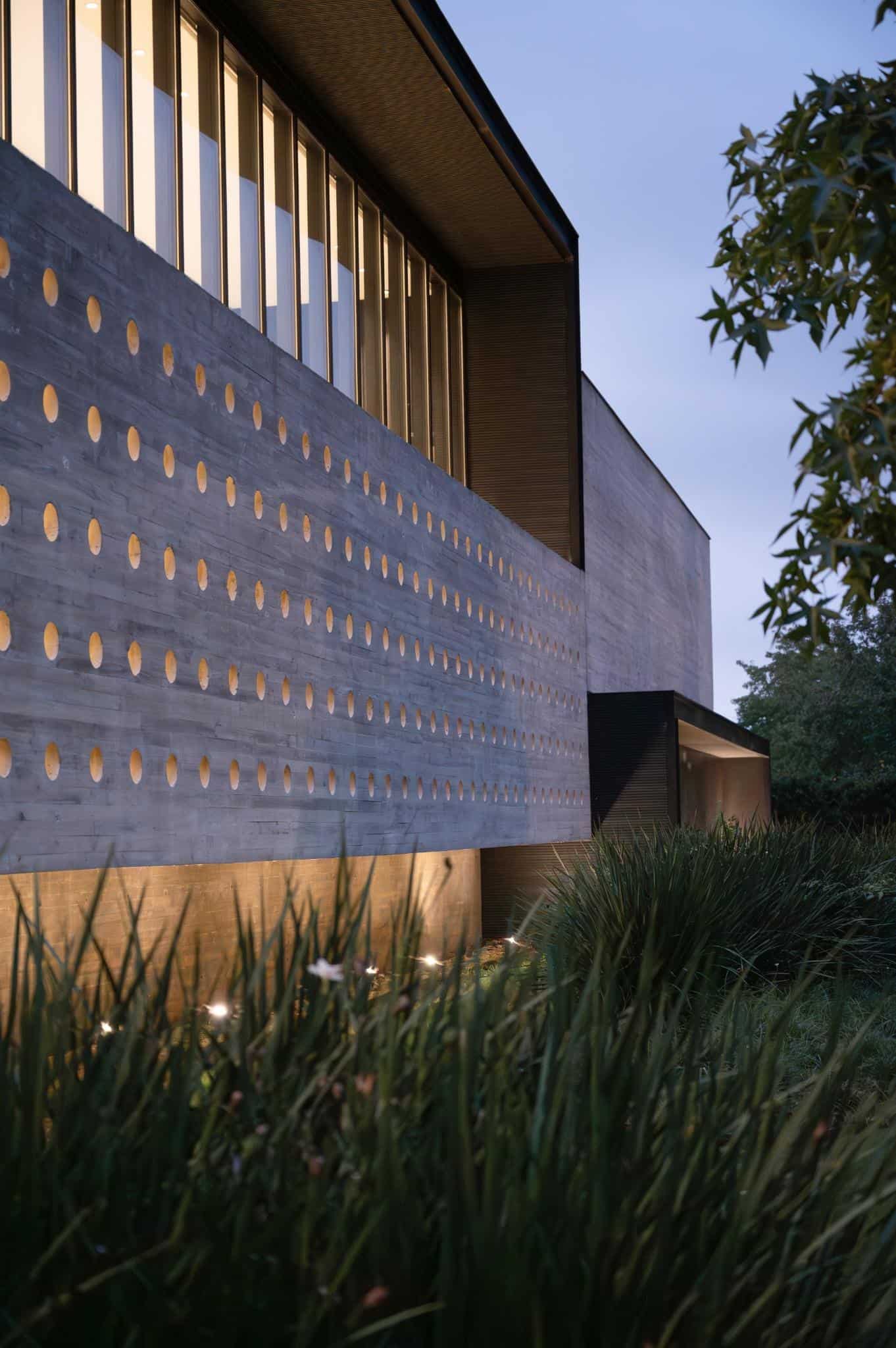 Pacheco House Facade Evening Lighting Warm lights glowing from the perforated facade of Pacheco House at dusk.