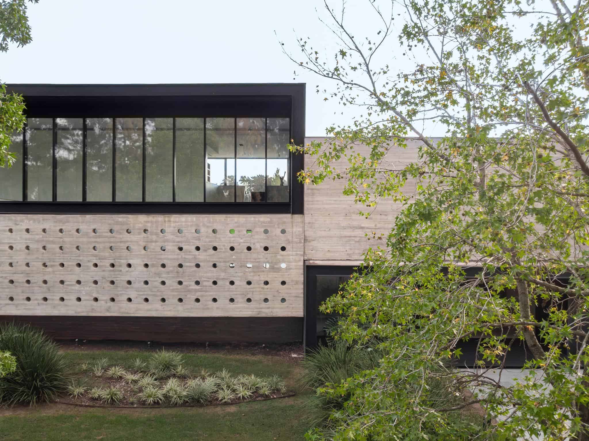 Pacheco House Facade Punched Windows Perforated concrete facade of Pacheco House with evenly spaced circular openings.