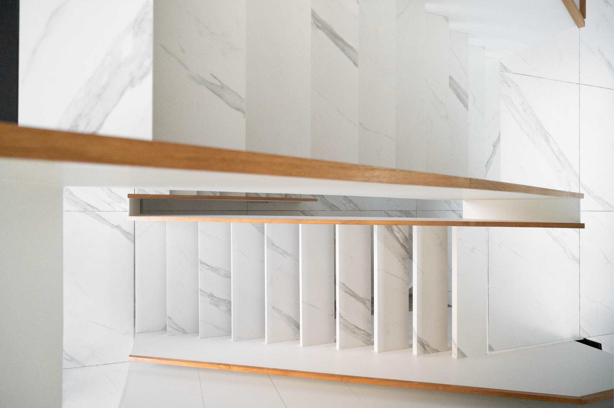Pacheco House Floating Stairs Closeup Close-up of white marble-clad floating stairs with wooden railing in Pacheco House.