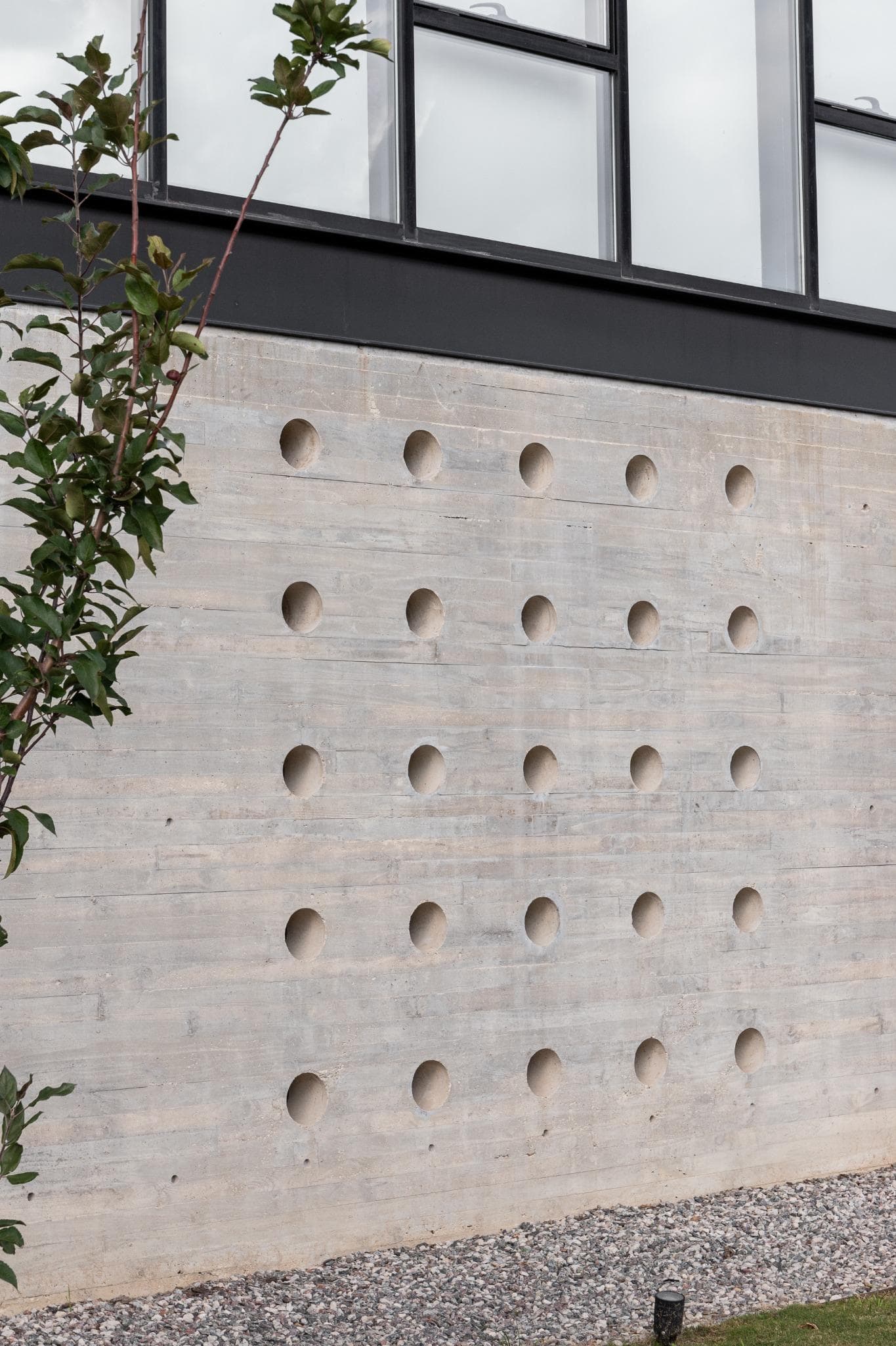 Pacheco House Punched Concrete Detail Close-up view of punctured concrete facade on the lower floor of Pacheco House.
