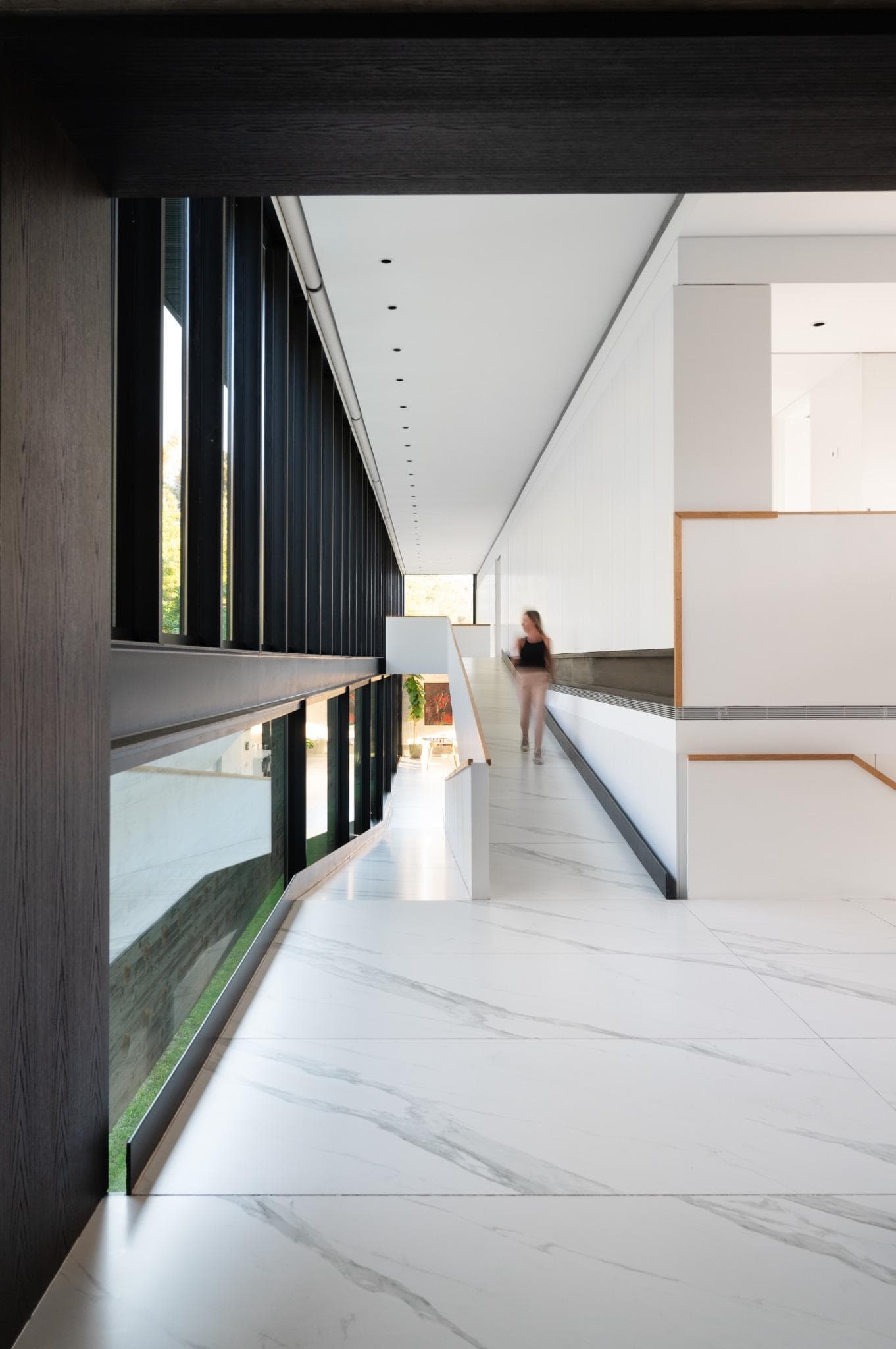 Pacheco House Upper Hallway Perspective Long interior hallway with floor-to-ceiling glazing and minimal white finishes in Pacheco House.