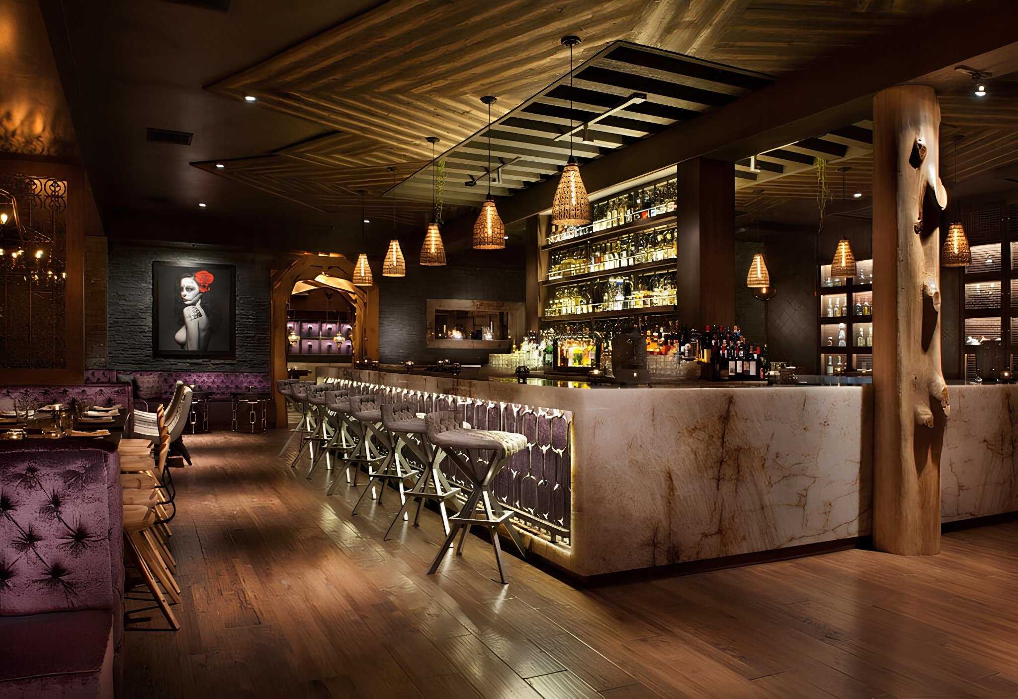 Elegant modern bar interior with warm lighting, wood accents, and luxurious seating; perfect example of contemporary architectural design in hospitality spaces.