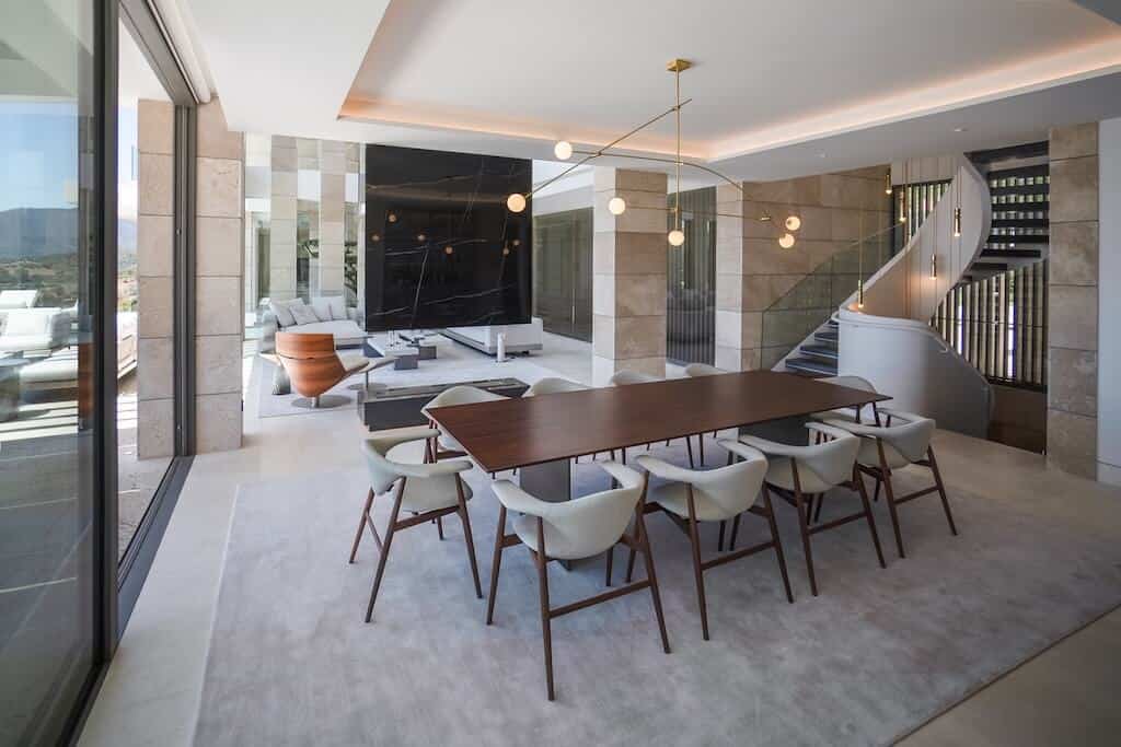 Villa Kaizen Dining Room and Spiral Staircase Elegant dining area with modern furniture and a sculptural spiral staircase in Villa Kaizen.