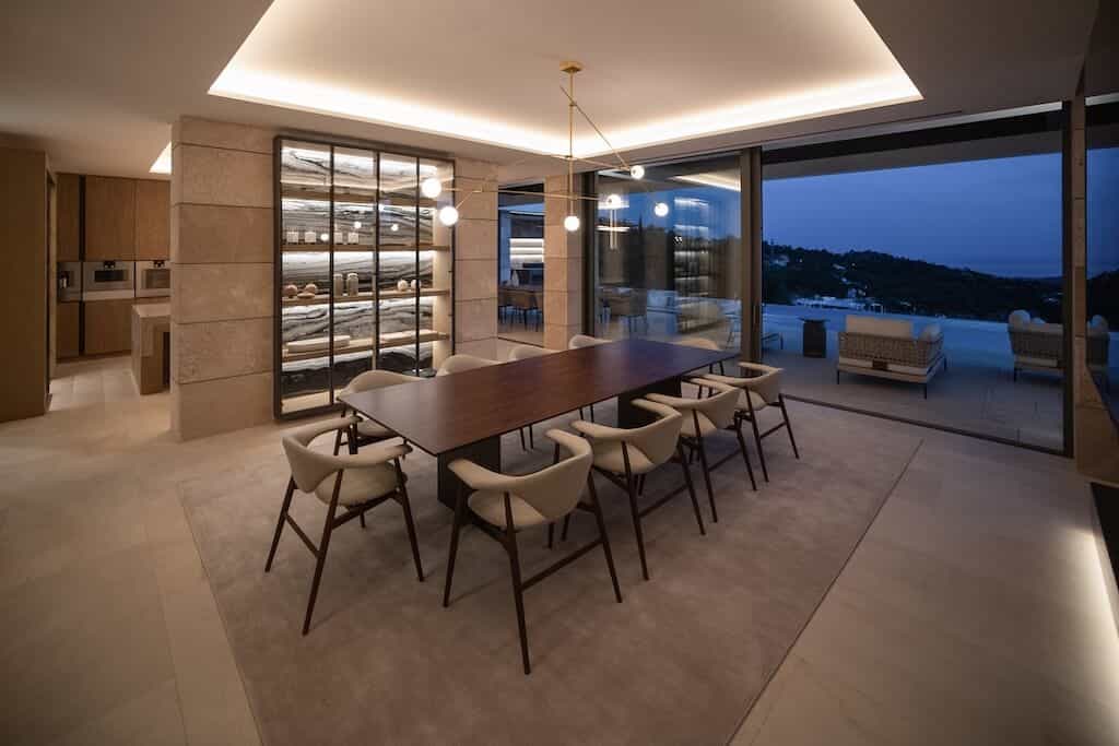 Villa Kaizen Dining Room Evening View Contemporary dining room at Villa Kaizen with poolside view under evening light.