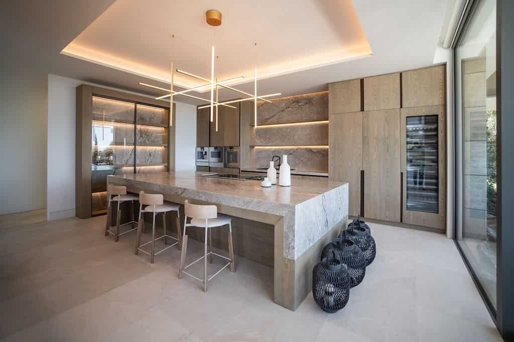 Villa Kaizen Kitchen Island Design Contemporary kitchen with natural stone island and ambient lighting in Villa Kaizen.