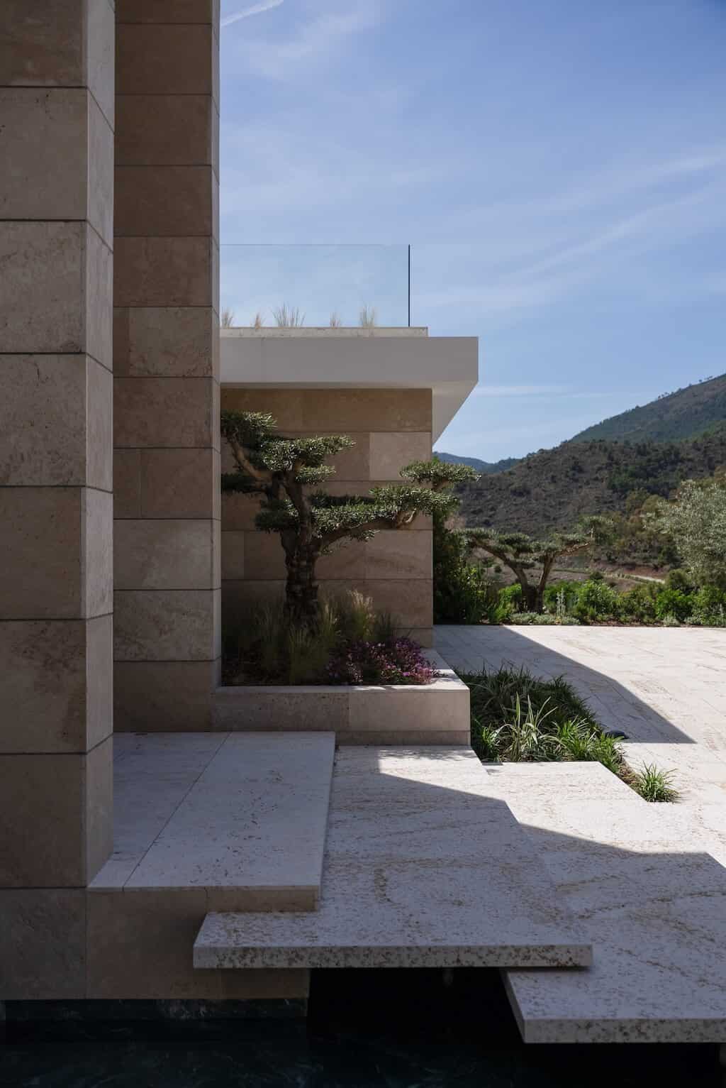 Villa Kaizen Olive Courtyard Corner Corner of Villa Kaizen’s courtyard with sculptural olive tree and mountain view.