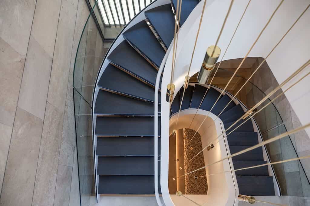 Villa Kaizen Spiral Staircase Top Down Top-down view of the spiral staircase at Villa Kaizen with suspended lights.