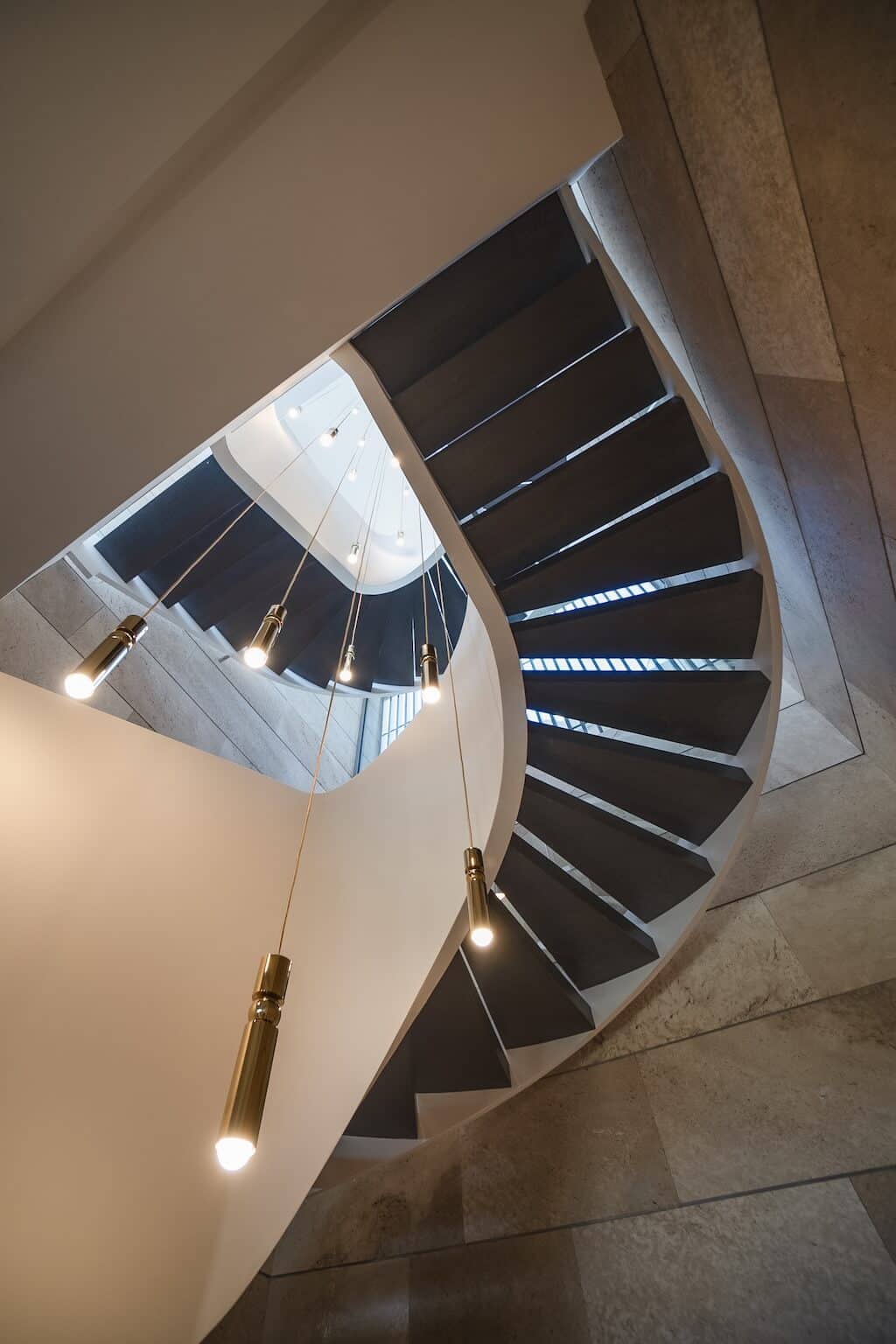 Villa Kaizen Spiral Staircase Upward View Looking up through the sculptural spiral staircase at Villa Kaizen with pendant lighting.