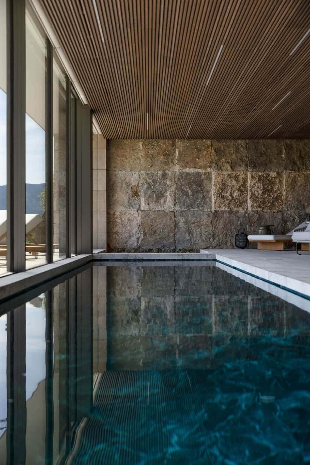 Villa Kaizen Stone Wall Poolside Textured stone wall beside the indoor pool at Villa Kaizen, evoking natural serenity.