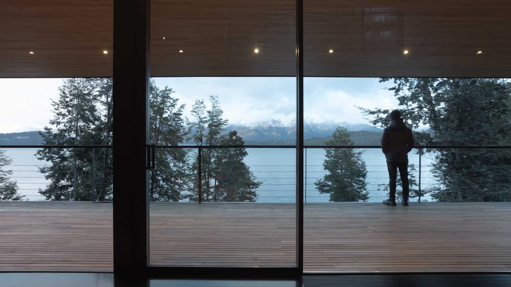 Resident on balcony of VLA House looking across the lake toward the mountains.