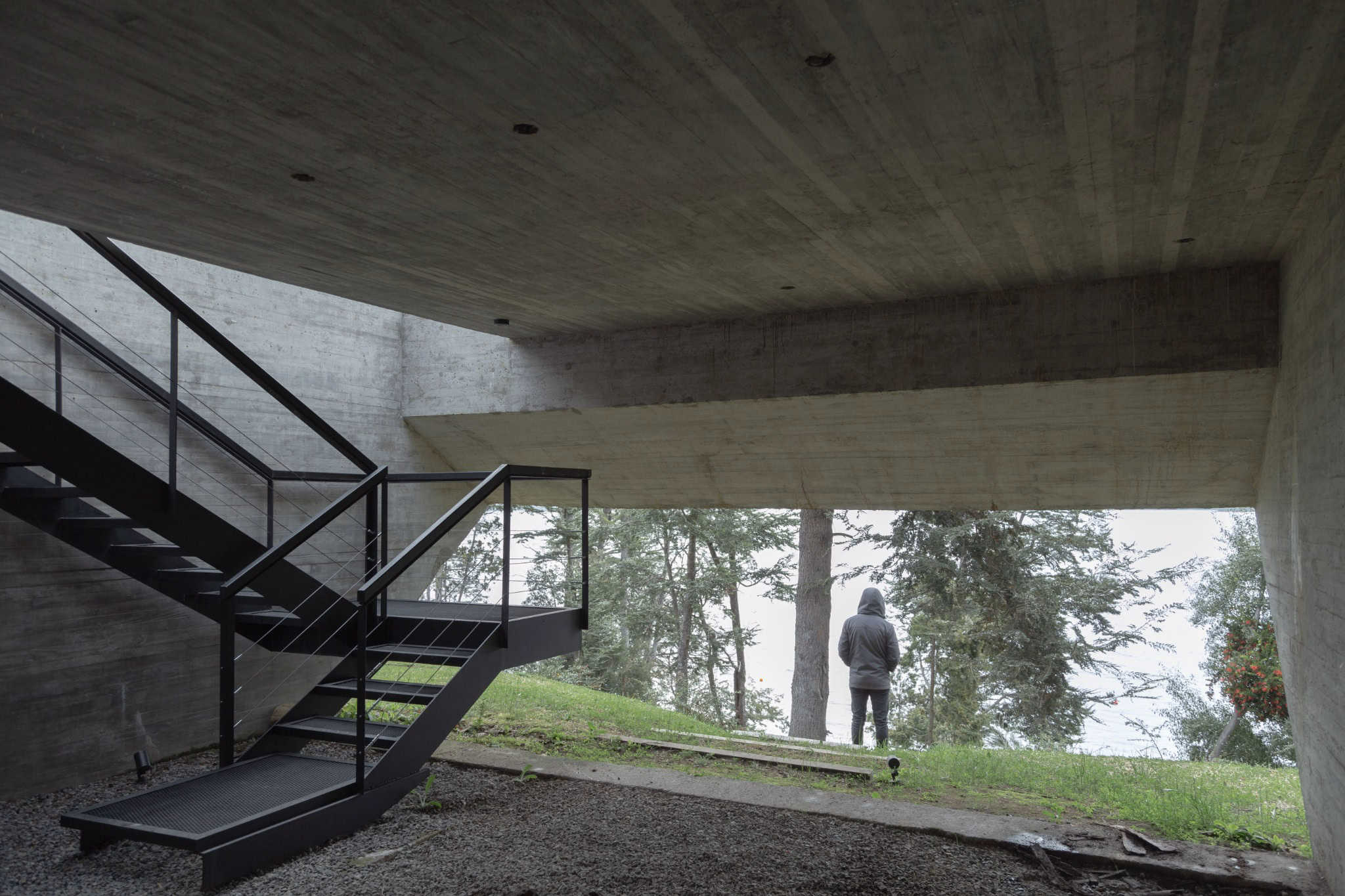 Concrete understructure of VLA House with steel staircase and garden.
