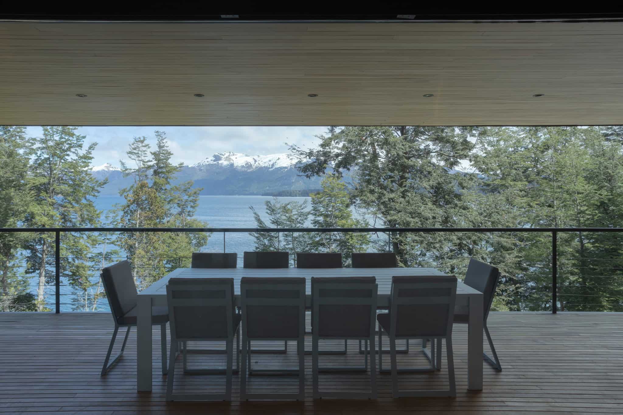 Outdoor dining area under covered terrace with view of Patagonian landscape.