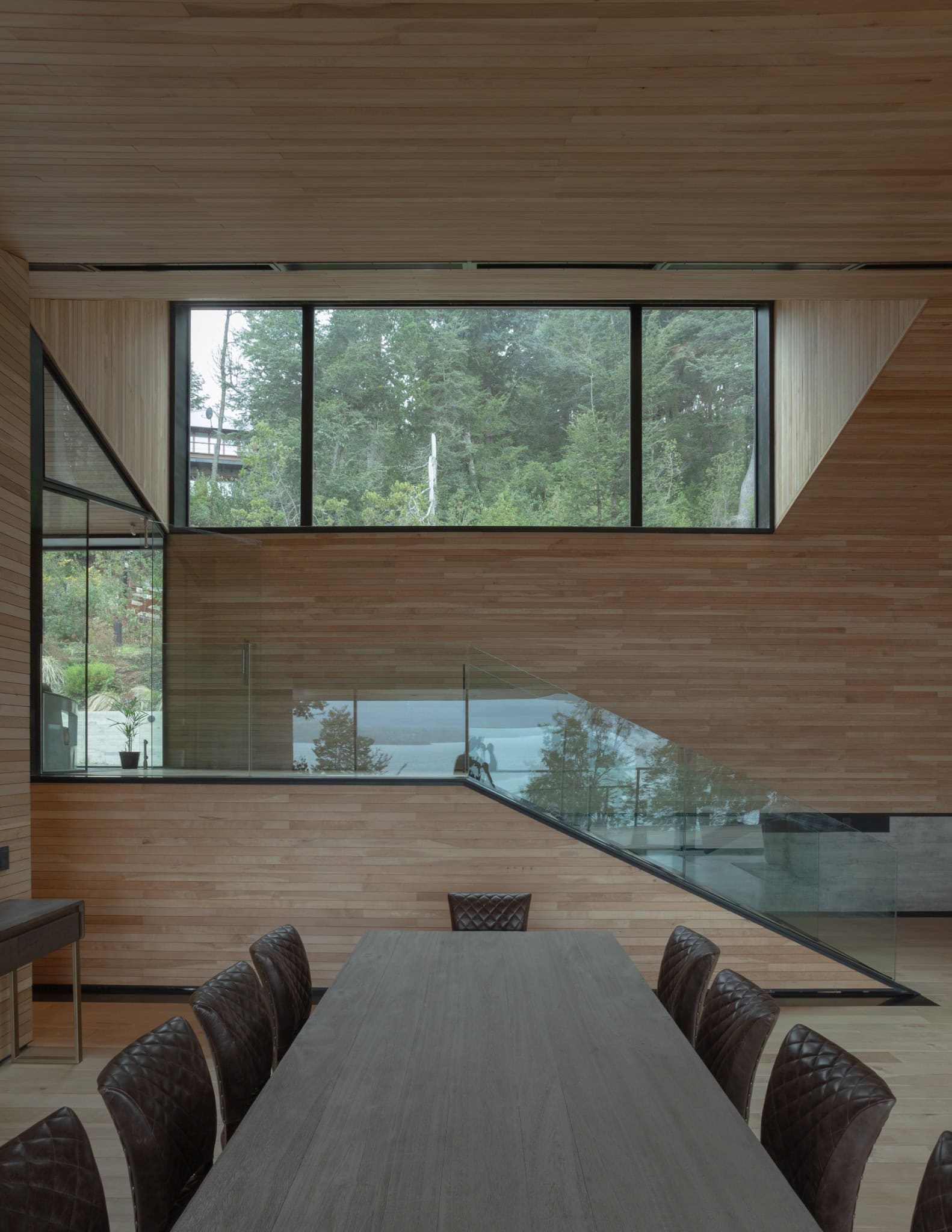 Dining room and staircase with glass balustrade inside VLA House by A4estudio.