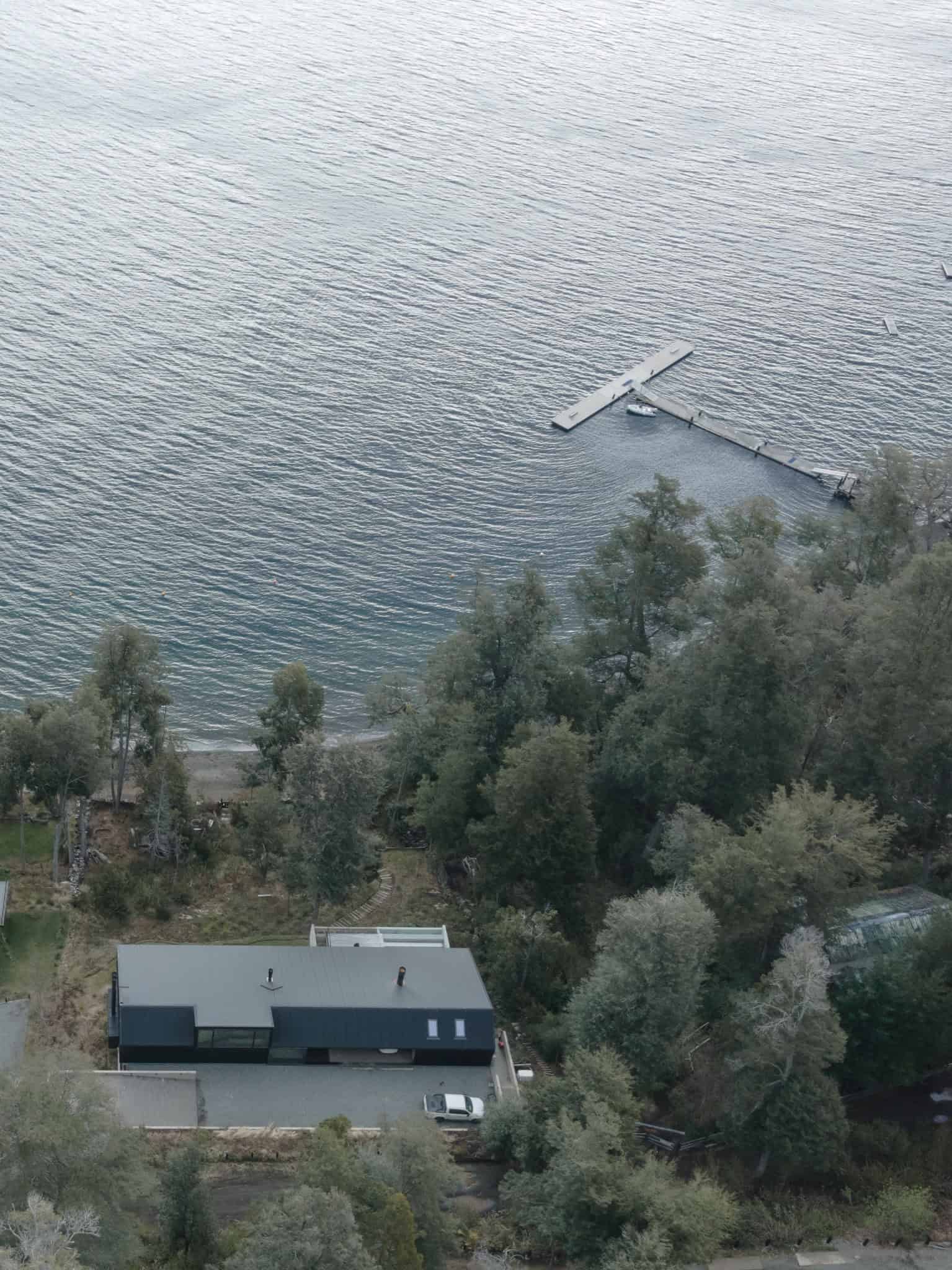 Aerial top-down view of VLA House and dock on Patagonian lake.