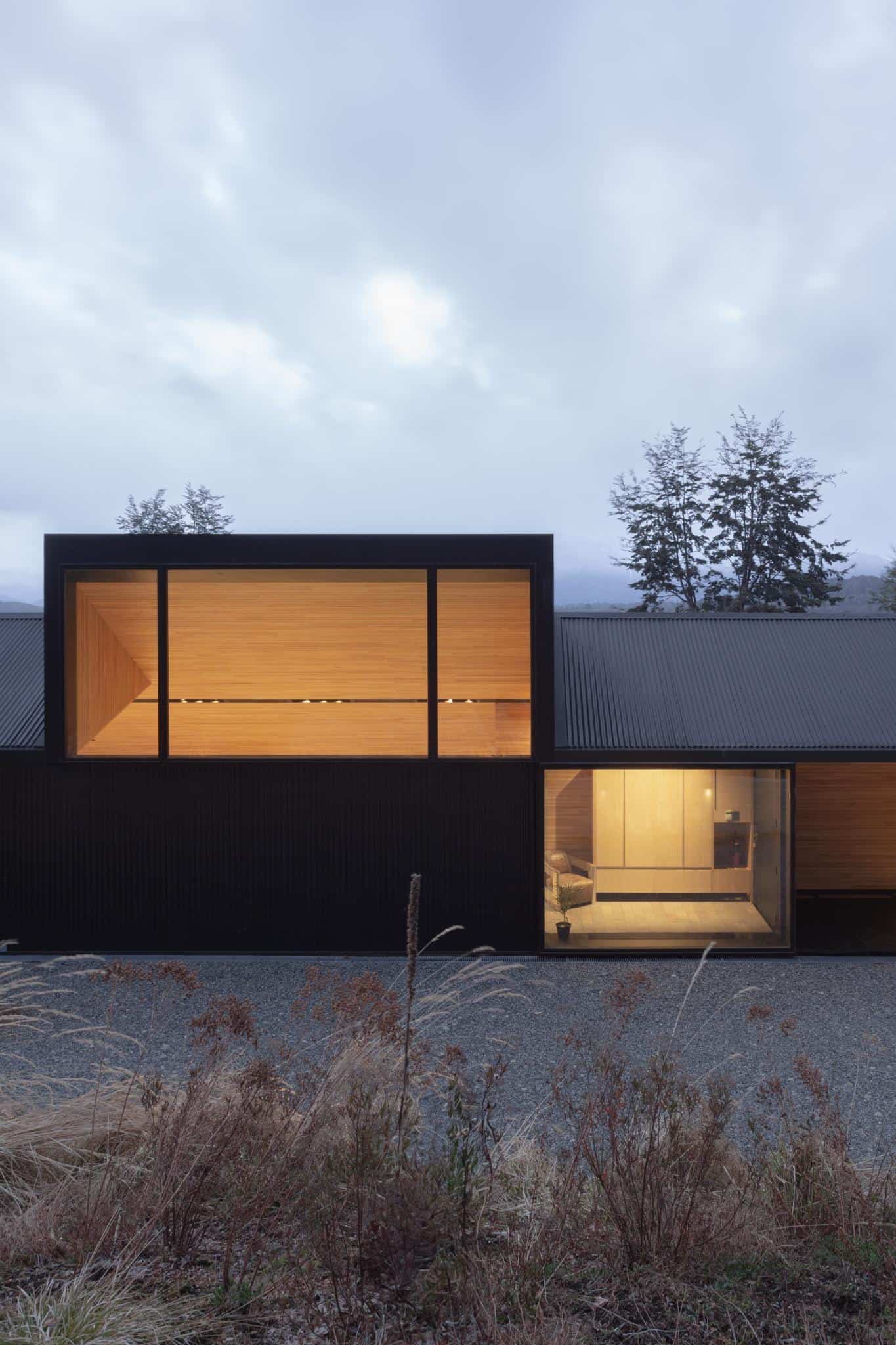 Exterior poolside view of VLA House by A4estudio illuminated in the evening.