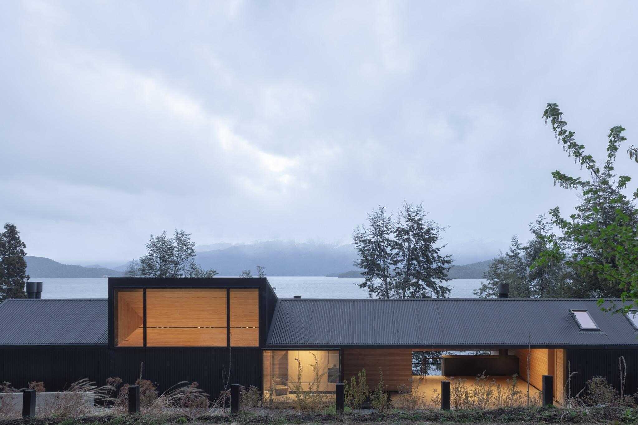 VLA House by A4estudio with full-length facade and lake in background.