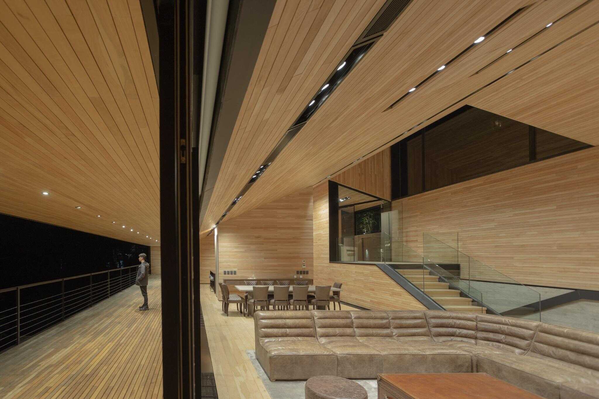 Open-plan interior with wood ceiling and modern furnishings at VLA House by A4estudio.