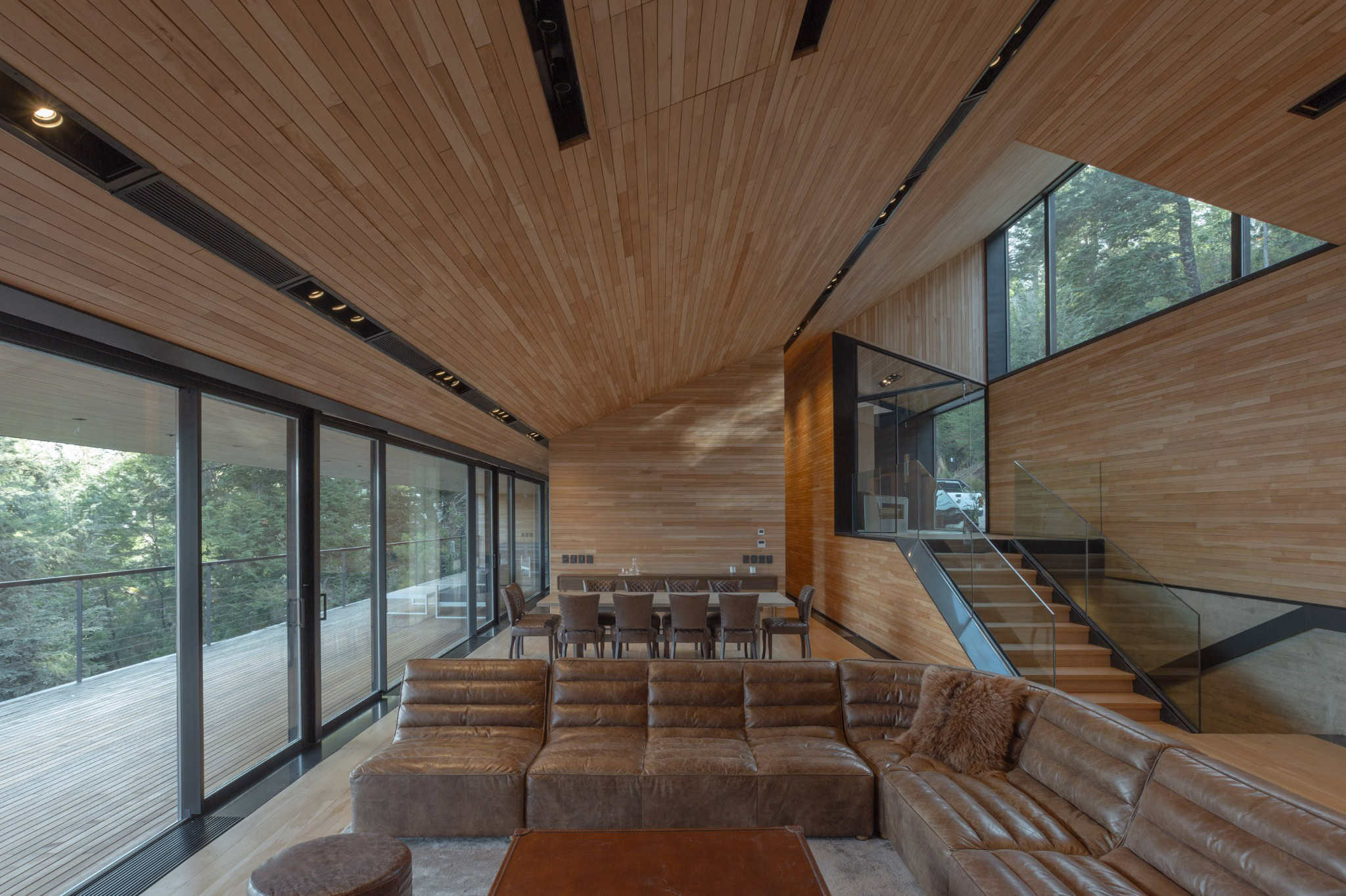 Open-plan living and dining space with timber cladding throughout at VLA House.