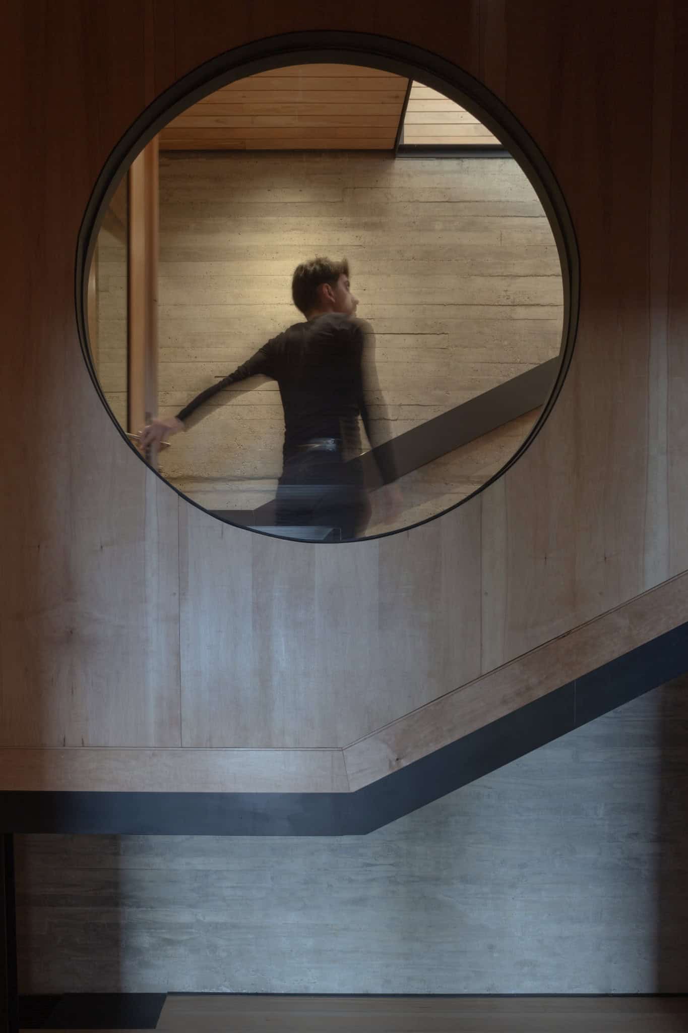 Circular window framing interior staircase scene inside VLA House.