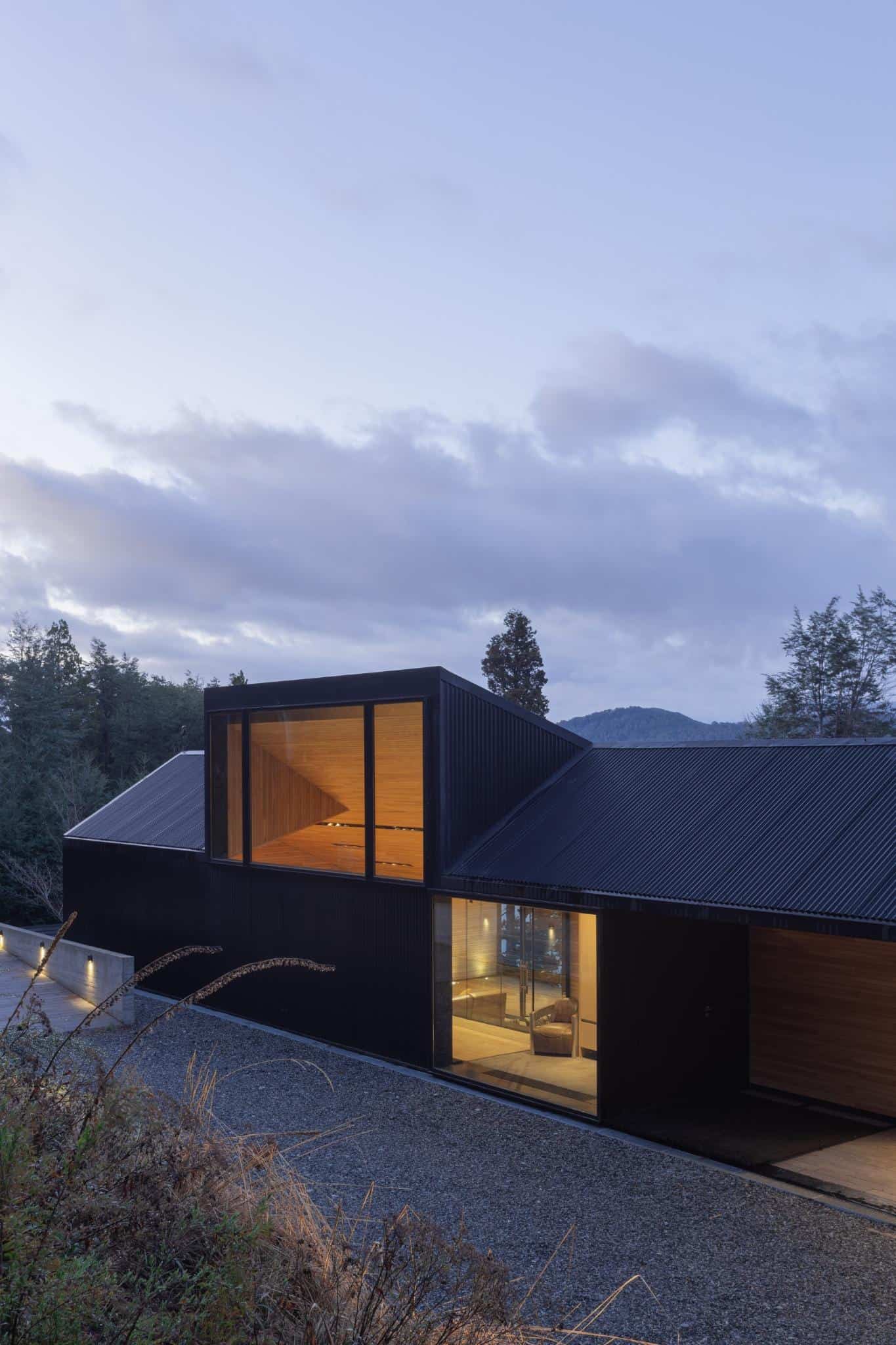 Side angle view of VLA House by A4estudio with glass facade details.