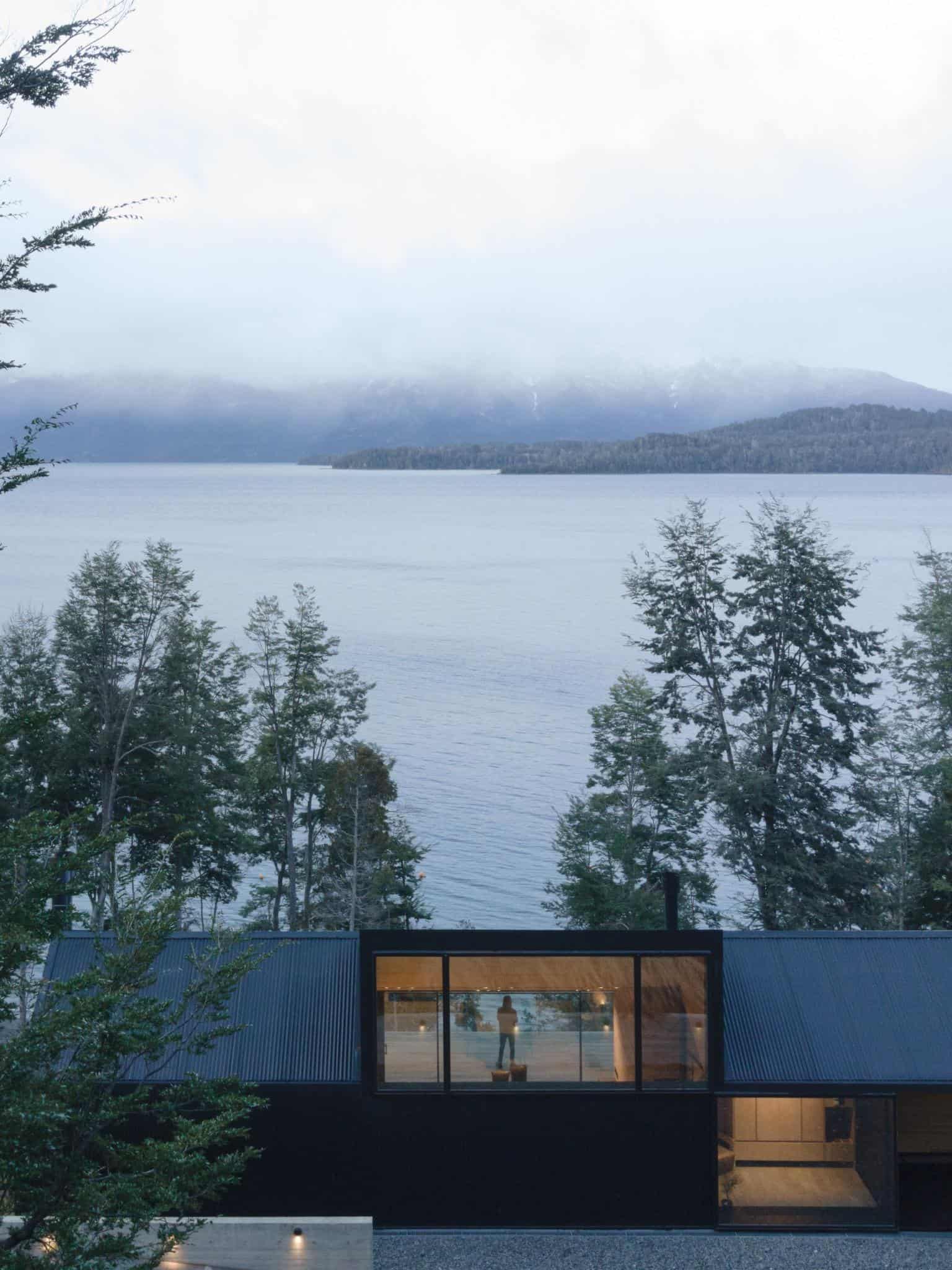 VLA House by A4estudio reflecting lake view through large window.