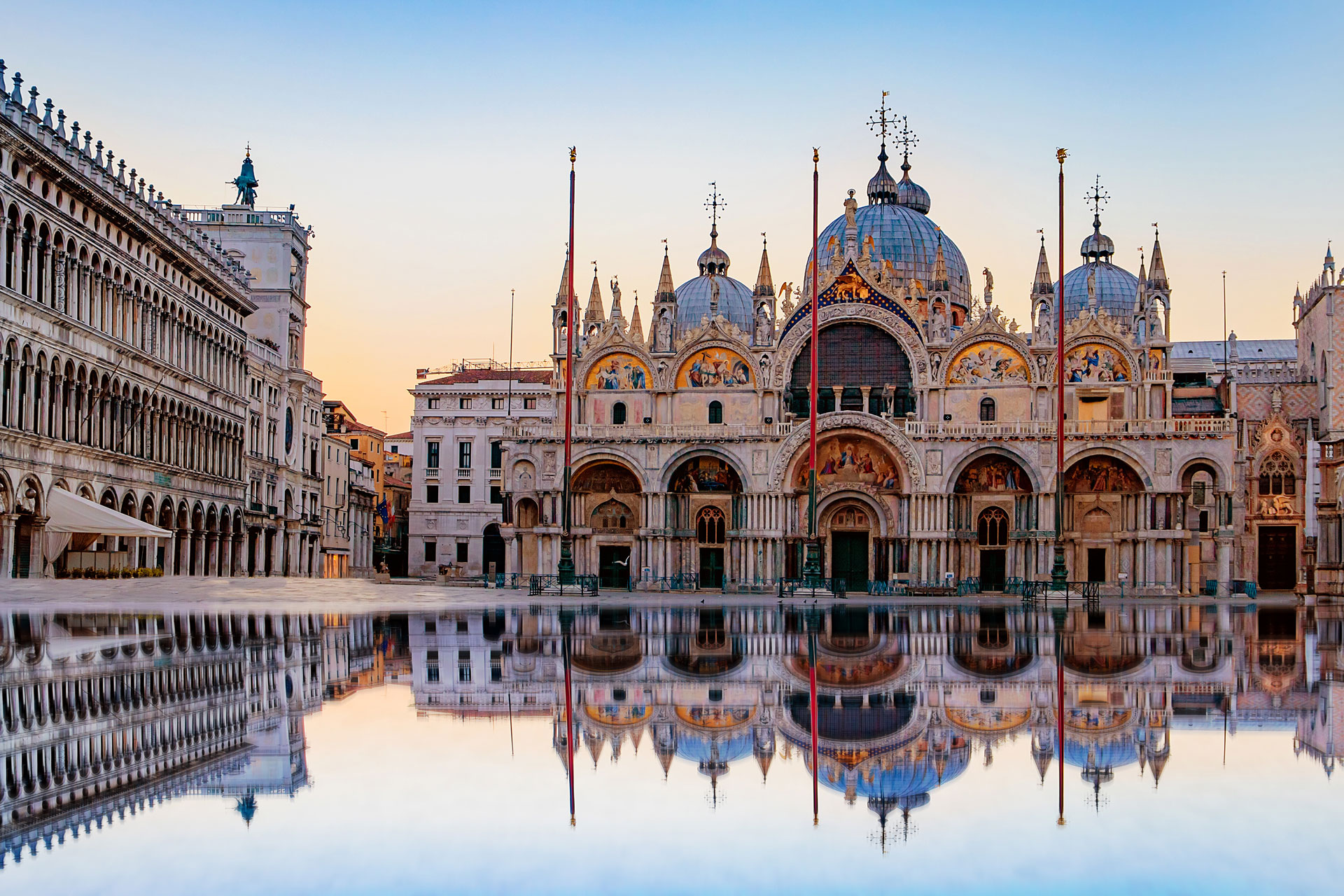 Front view of St. Mark’s Basilica in Venice with domes, gold mosaics and ornate details