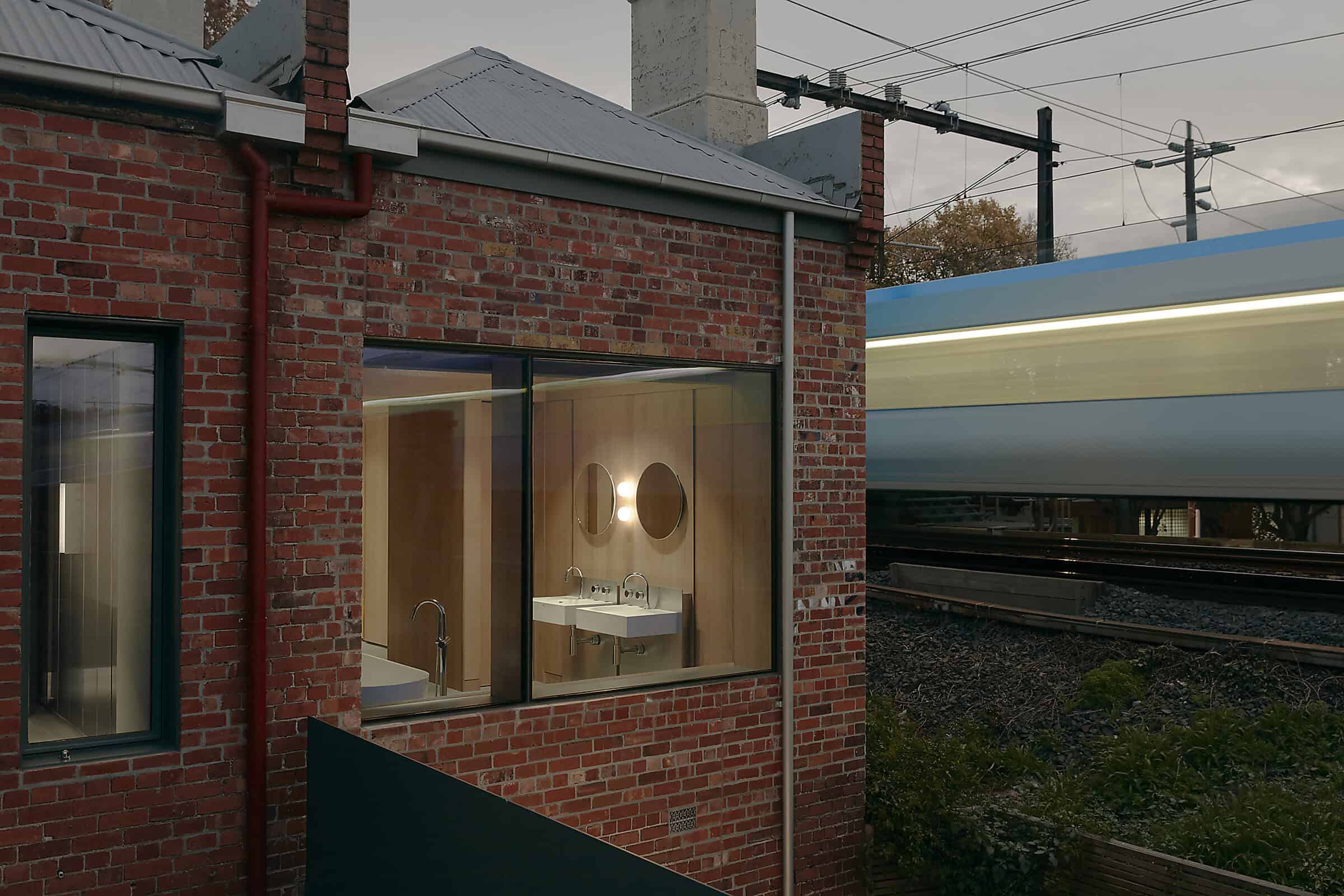 Modern brick building with large glass windows and urban landscape.
