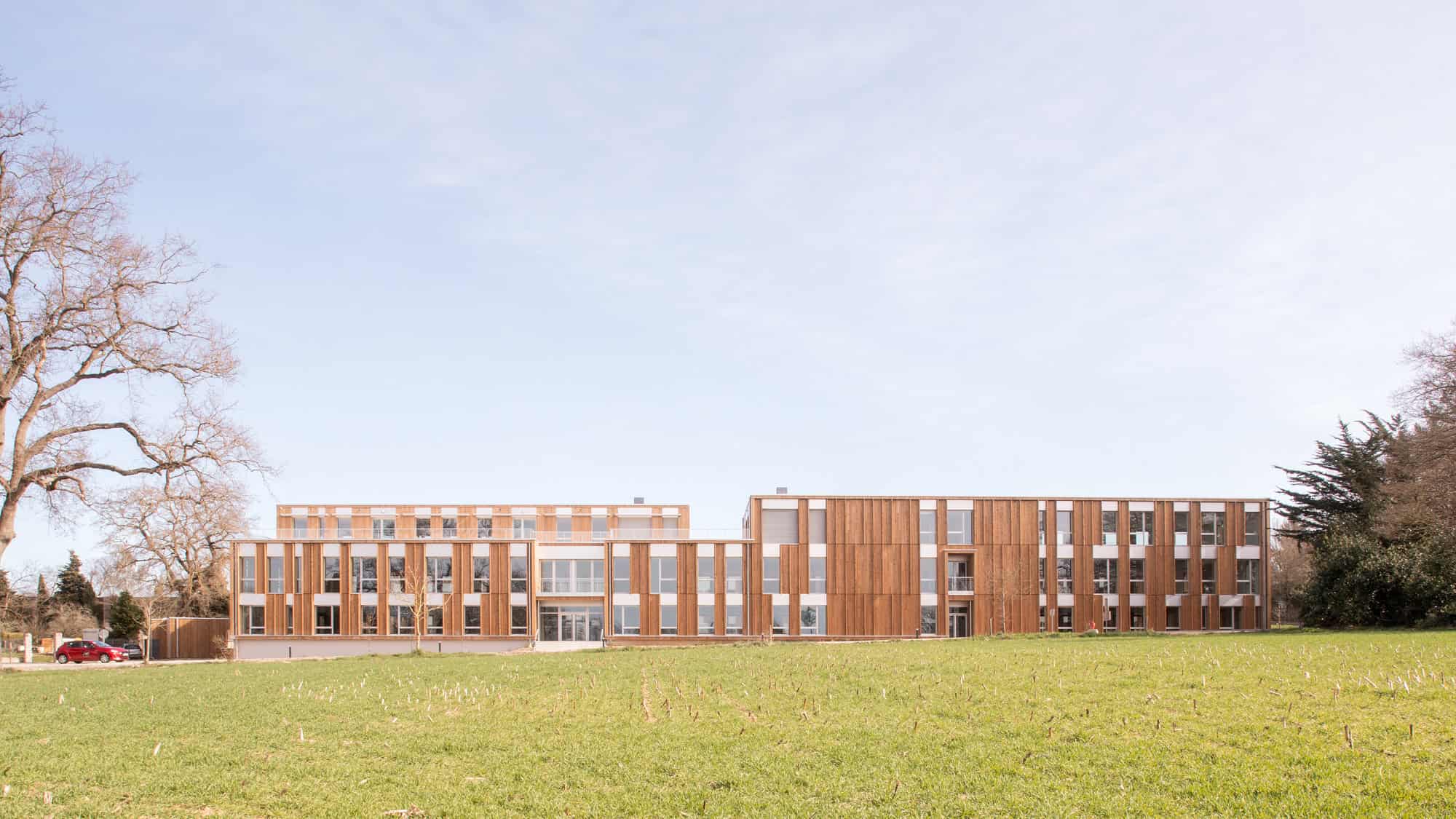 Modern architectural building showcasing sustainable design and wooden facade elements in a serene natural setting.