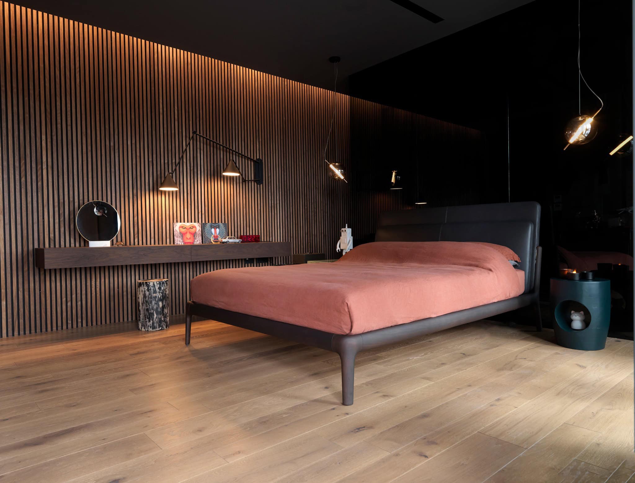 Modern bedroom interior with sleek dark furniture, wooden accent wall, soft lighting, and contemporary decor design for stylish home architecture.
