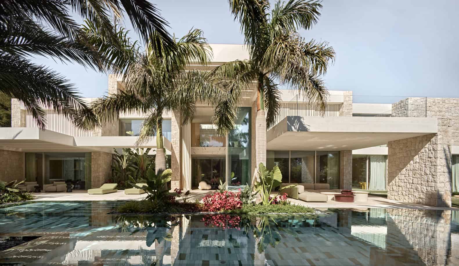Luxury modern villa with a stunning outdoor pool, contemporary architecture, and lush landscaping, ideal for upscale residential design and outdoor living spaces.