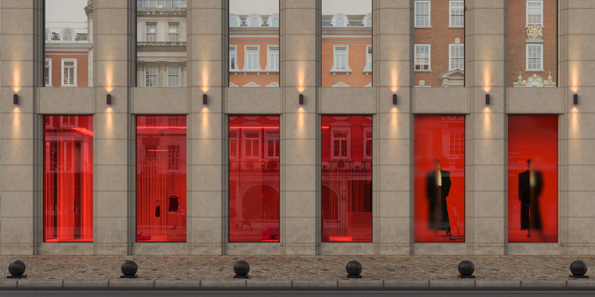 Vibrant red storefront windows with mannequins showcasing modern fashion, housed in a contemporary building with sleek concrete facade and warm exterior lighting, reflecting an urban commercial design.