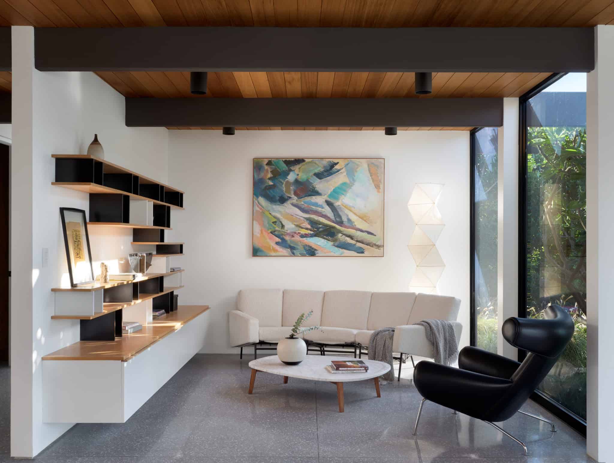 Malibu Glass Box House by Klopf Architecture – sitting room with shelves and art, Malibu, California