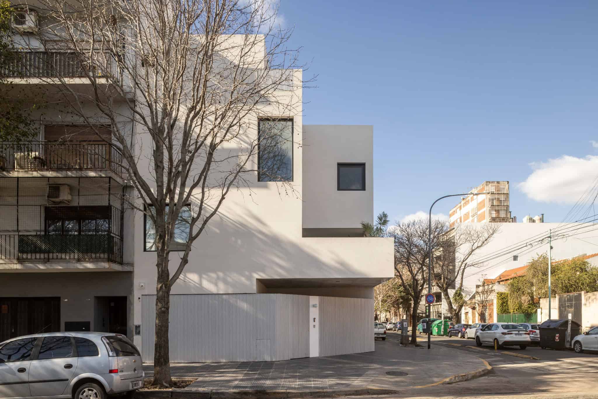 Modern minimalist residential building showcasing sleek white exterior and contemporary architectural design.