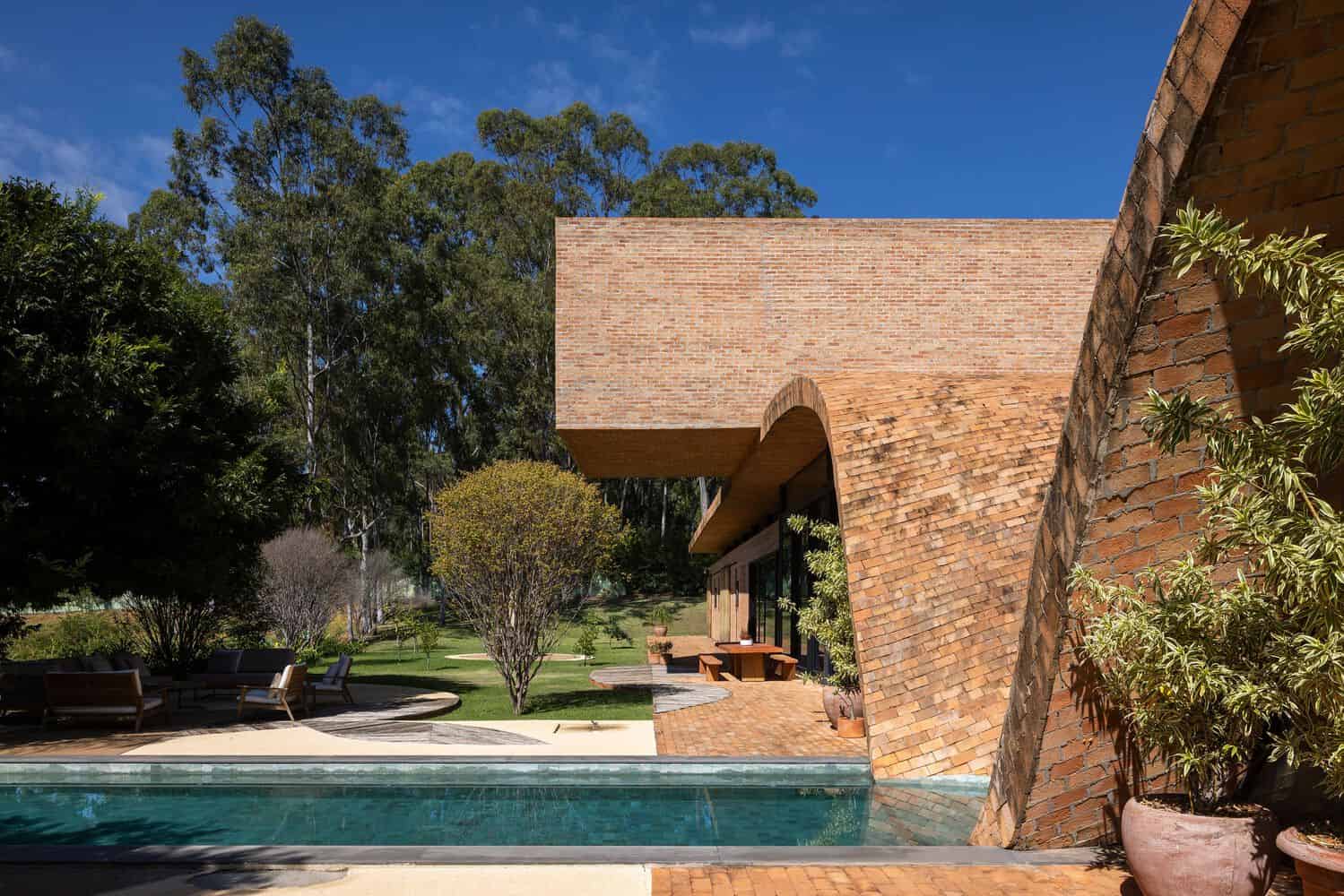 Passive House Pool and Cantilever by Mareines Arquitetura Passive House pool and cantilevered brick volume in São Paulo, Brazil