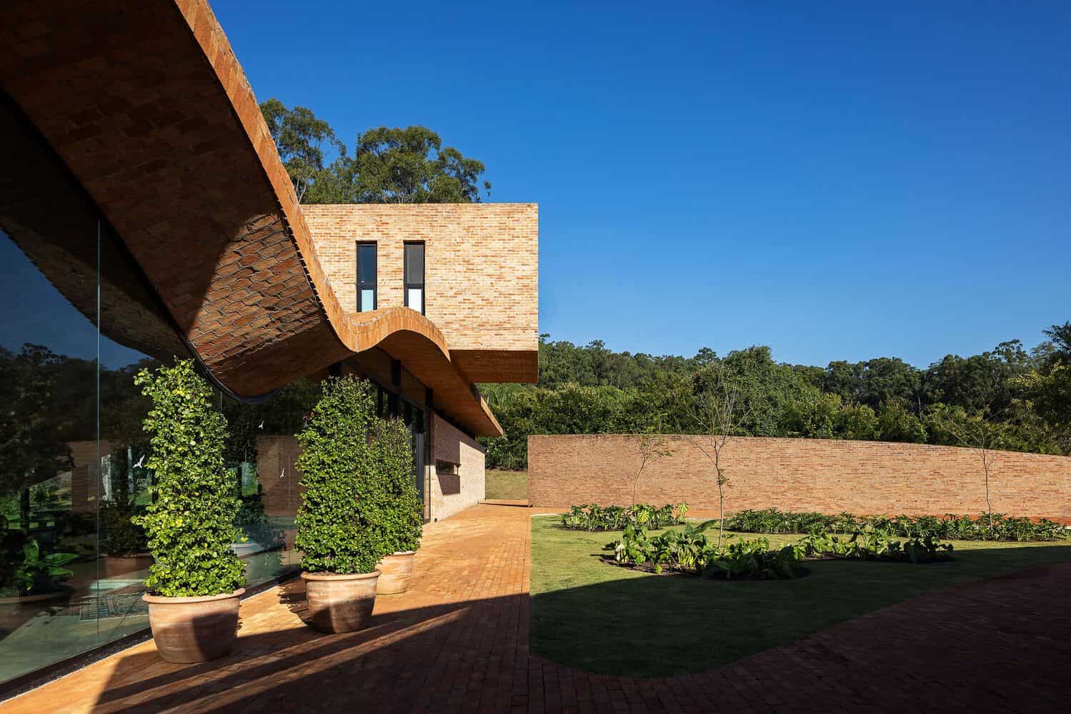 Passive House Wave Roof Courtyard by Mareines Arquitetura Passive House wave-shaped brick roof over courtyard, São Paulo, Brazil