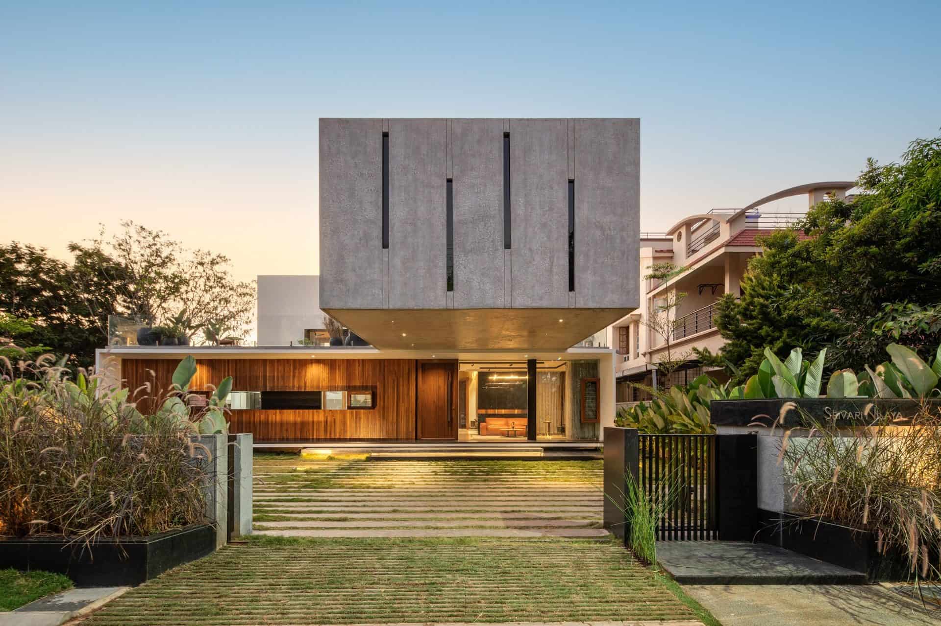 Contemporary modern house with minimalist concrete and wood exterior, lush landscaping, and sleek architectural design showcasing innovative architecture and stylish residential architecture.