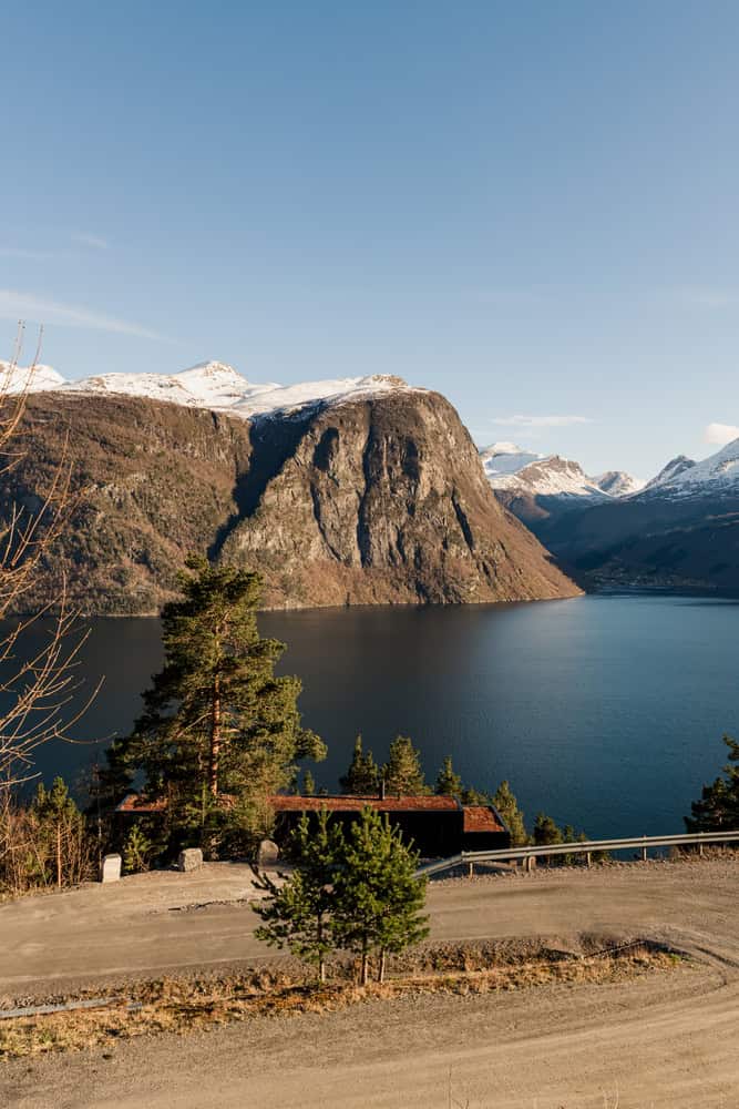 18-07 Holiday Home Aerial Approach by OFFICE INAINN 18-07 Holiday Home by OFFICE INAINN, aerial approach from mountain road above Norwegian fjord