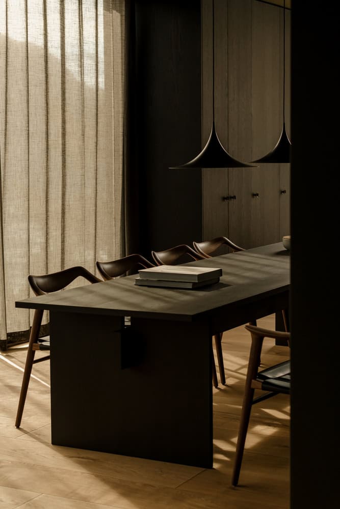 18-07 Holiday Home Dining Room Detail by OFFICE INAINN 18-07 Holiday Home by OFFICE INAINN, dark wood dining area with sculptural pendant lights in coastal Norway