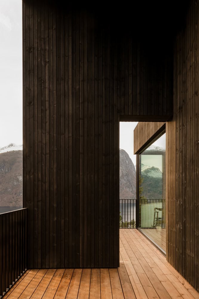 18-07 Holiday Home Timber Courtyard Walk by OFFICE INAINN 18-07 Holiday Home by OFFICE INAINN, timber decked passage framing fjord view in Norway