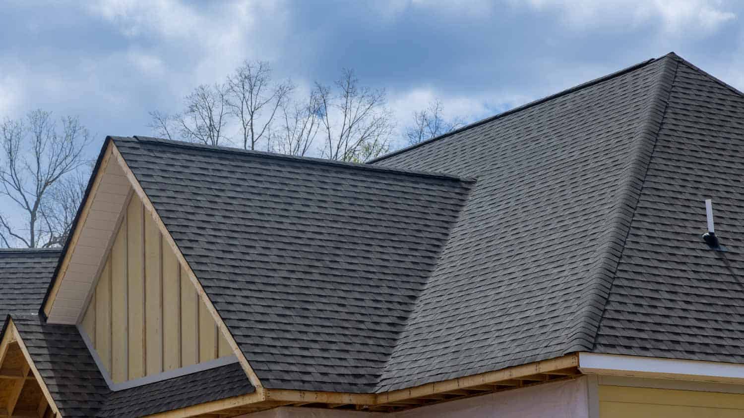 Asphalt shingle roof on a modern gable house—affordable, durable roofing material in architectural shingle profile