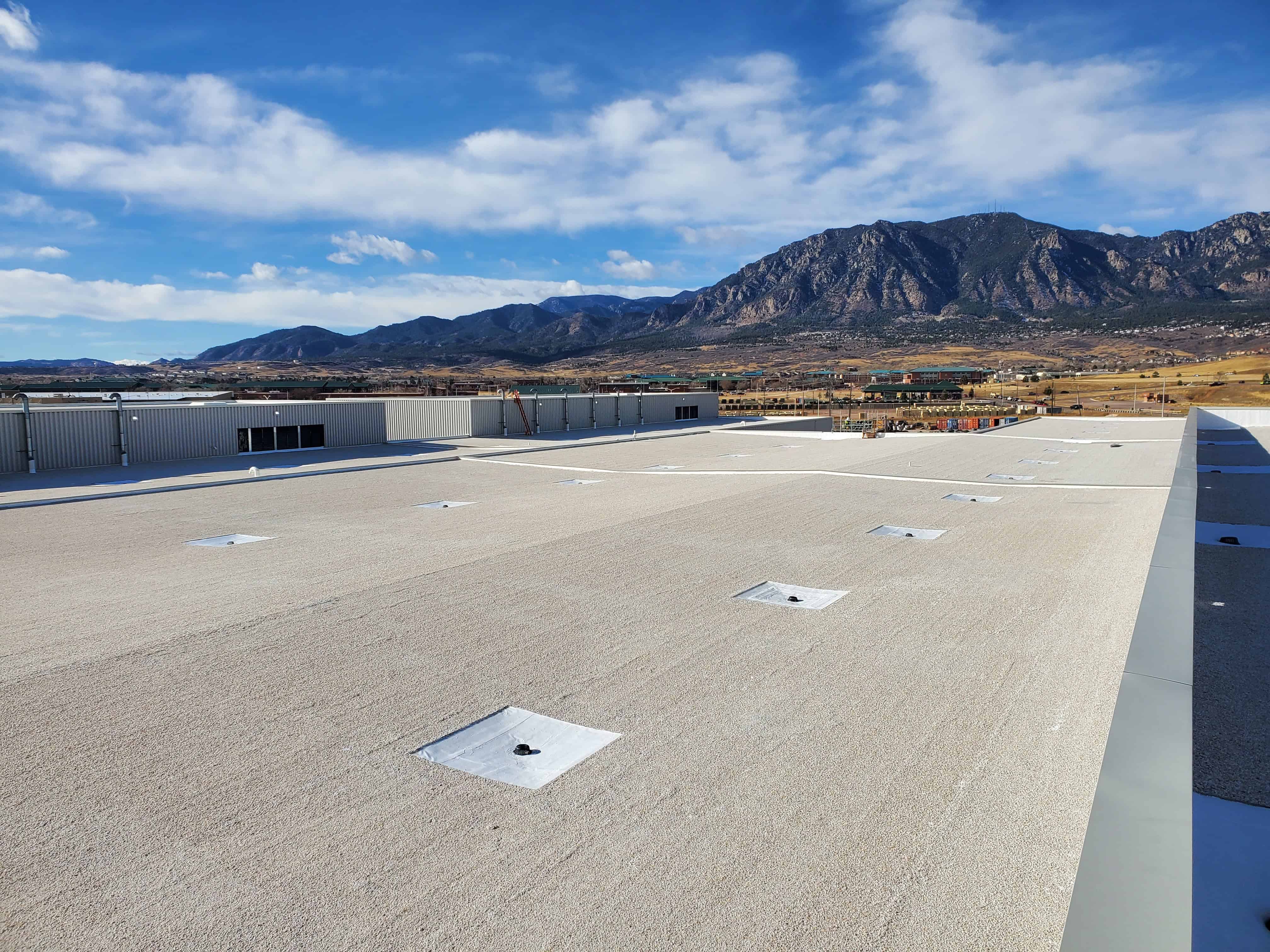 Commercial flat roof with built-up roofing system—multiple asphalt and gravel layers for durability and waterproofing