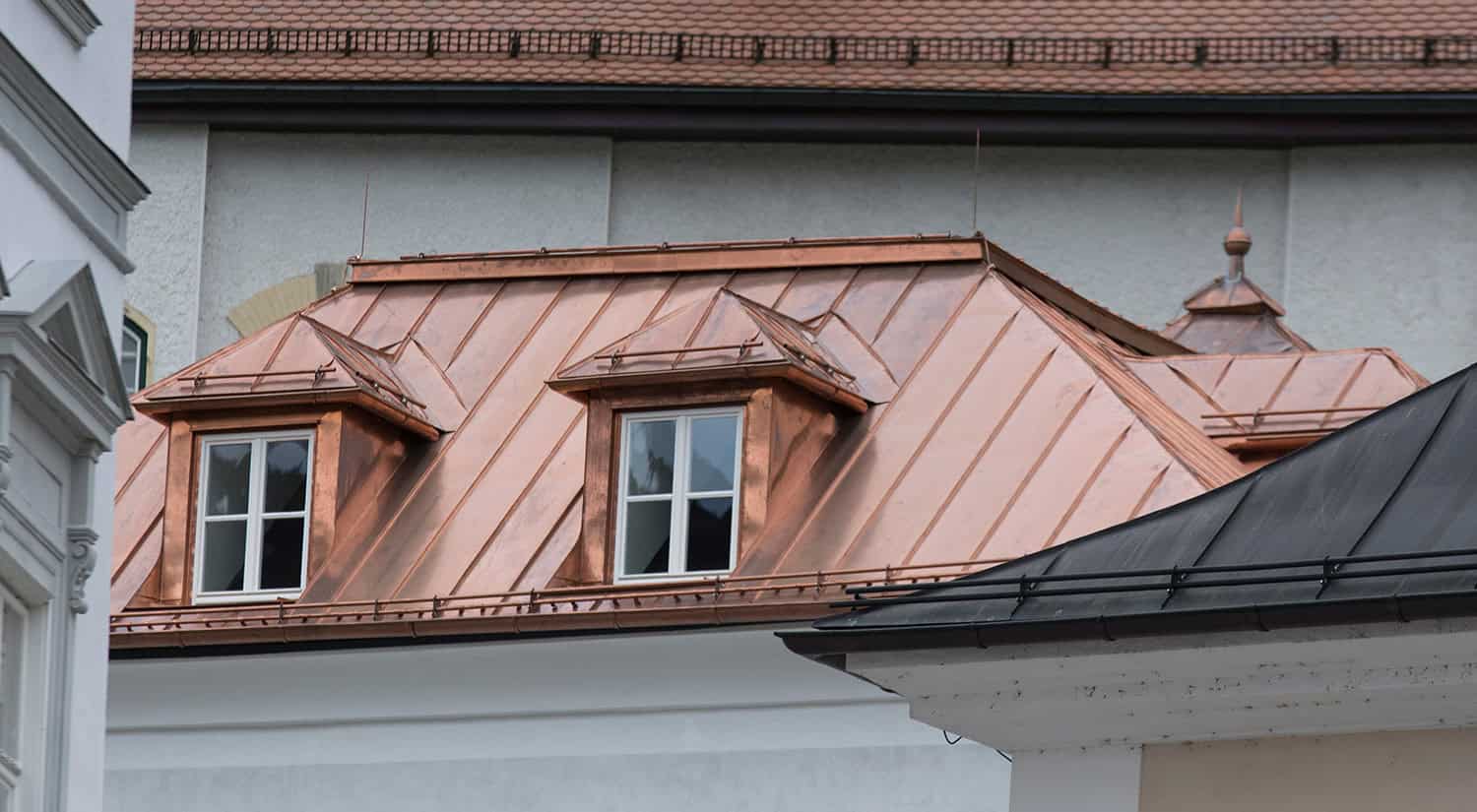 Architectural building with copper roof—premium metal roofing developing natural green patina over time