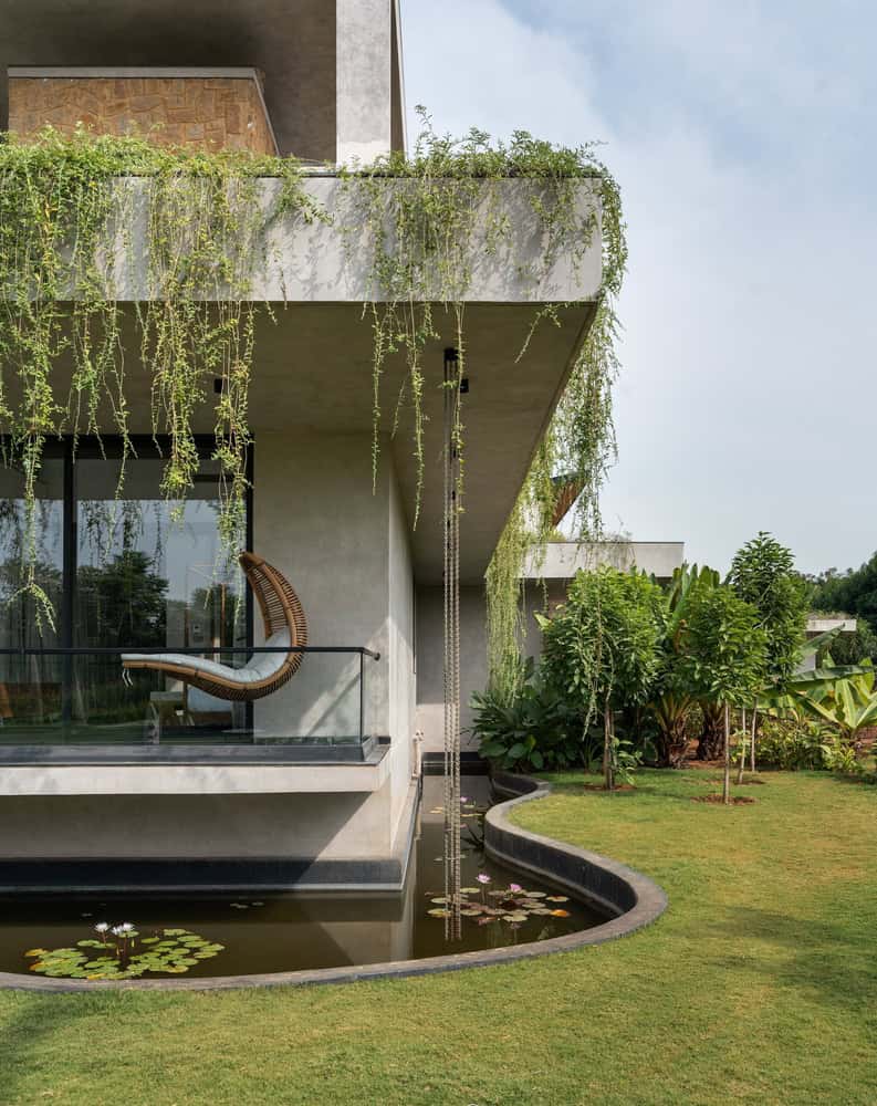 Antriya House Balcony Swing, Rain Chains & Pond by 23 Degrees Design Shift Antriya House by 23 Degrees Design Shift — balcony swing with rain chains over lily pond, Hyderabad, India