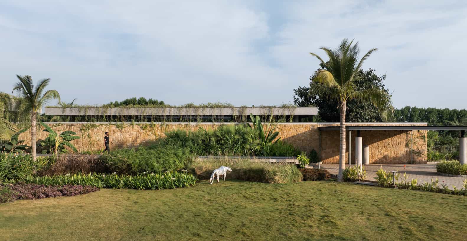 Antriya House Stone Facade Landscape by 23 Degrees Design Shift Antriya House by 23 Degrees Design Shift — stone facade set in layered landscape, Hyderabad, India