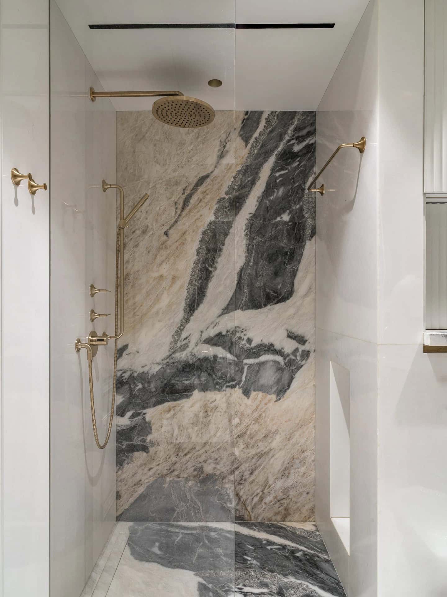 Apartment with a Parisian Mood for Collectors Bathroom Shower by AABA Architects Walk-in shower with marble walls and brass rain shower — AABA Architects, Moscow
