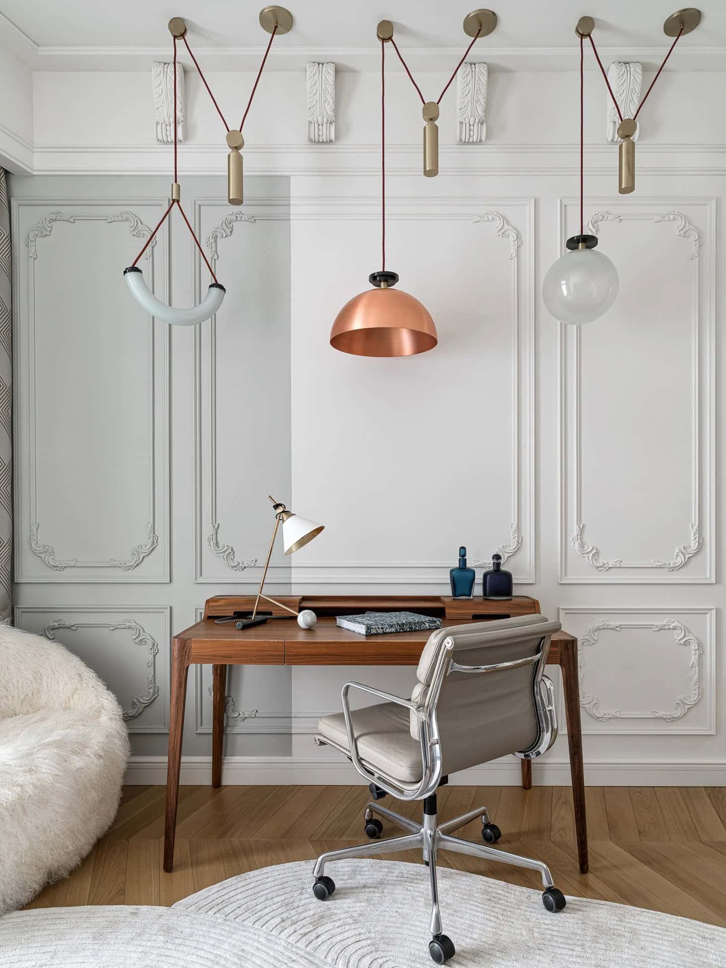 Apartment with a Parisian Mood for Collectors Desk Lighting Detail by AABA Architects Desk with decorative pulley pendant lights against ornate wall panels — AABA Architects, Moscow