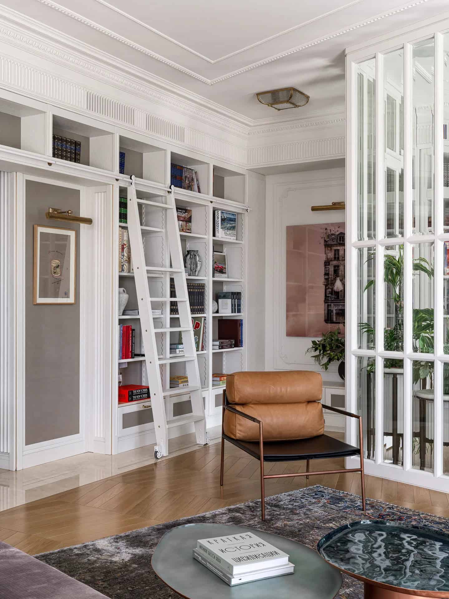 Apartment with a Parisian Mood for Collectors Library with Ladder by AABA Architects Built-in library wall with rolling ladder in the Apartment with a Parisian Mood for Collectors by AABA Architects, Moscow