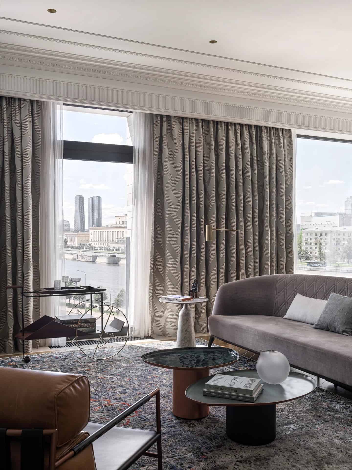 Apartment with a Parisian Mood for Collectors Living Room River View by AABA Architects Living room seating with river view windows in the Apartment with a Parisian Mood for Collectors by AABA Architects, Moscow